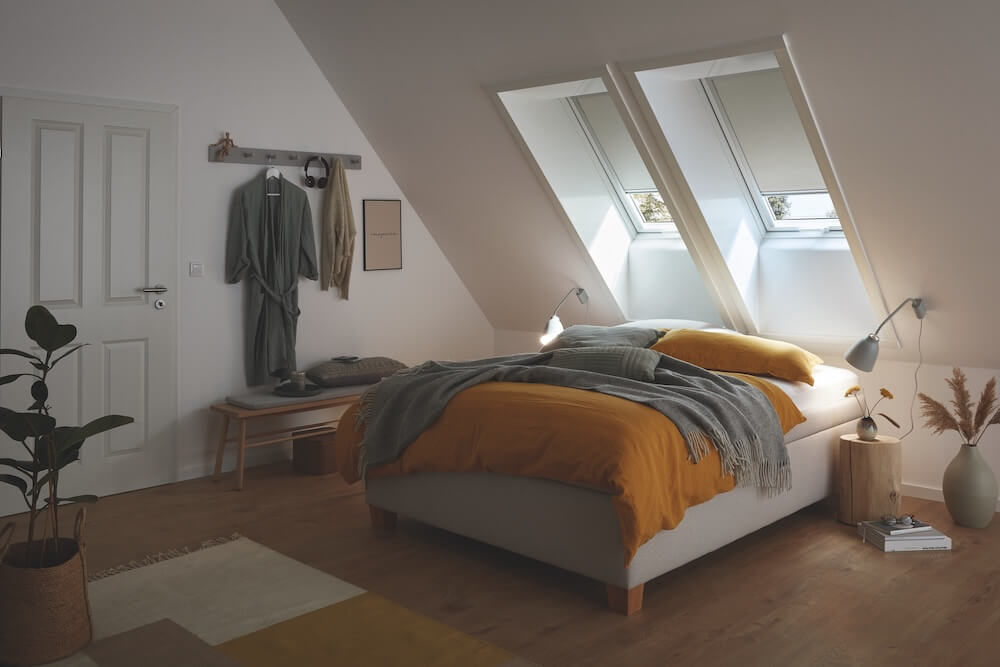Schlafzimmer mit Roto Dachfenstern mit Verdunkelungsrollos über dem Bett