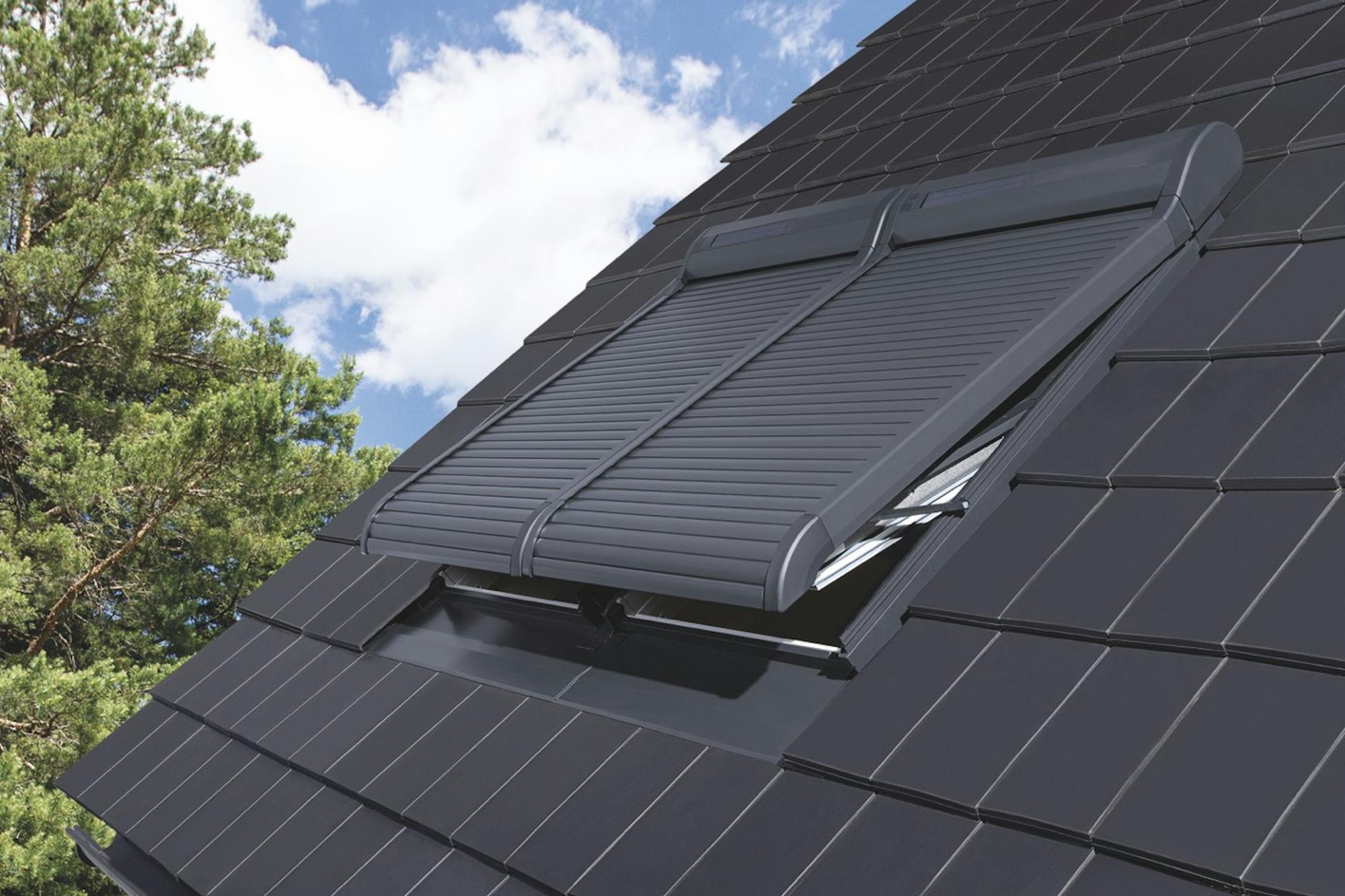 Mehrere Dachfenster mit modernen Außenrollläden auf einem Schrägdach – effektiver Hitzeschutz & Sichtschutz durch elektrische Rollläden.