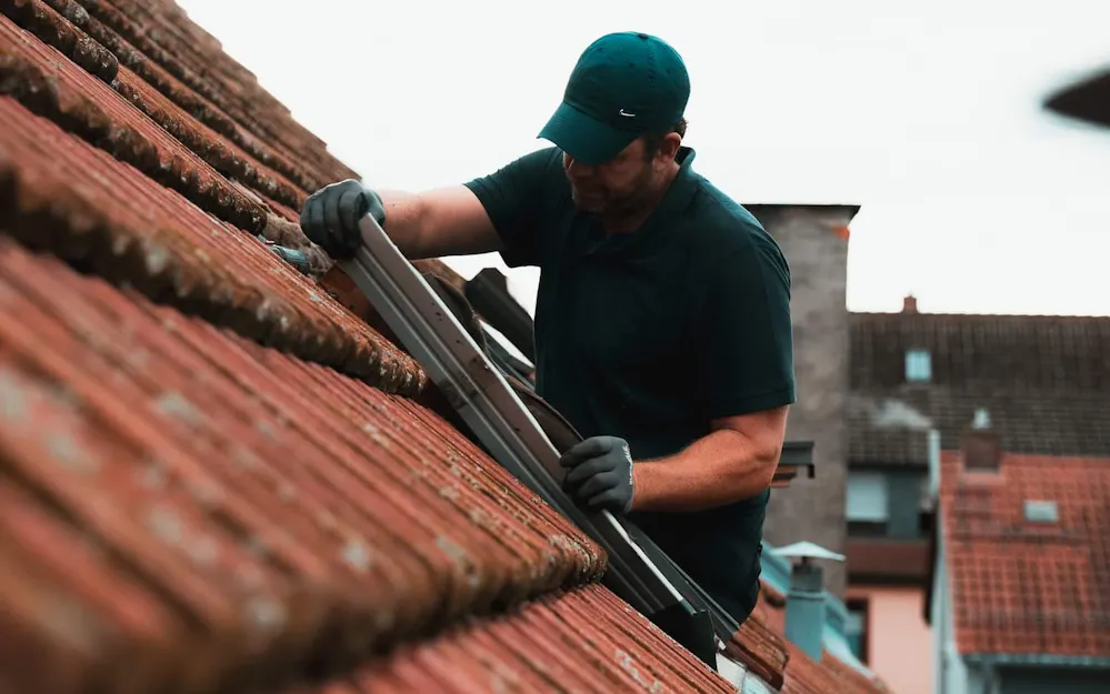 Handwerker repariert Velux Dachfenster von außen Handwerker repariert Velux Dachfenster von außen
