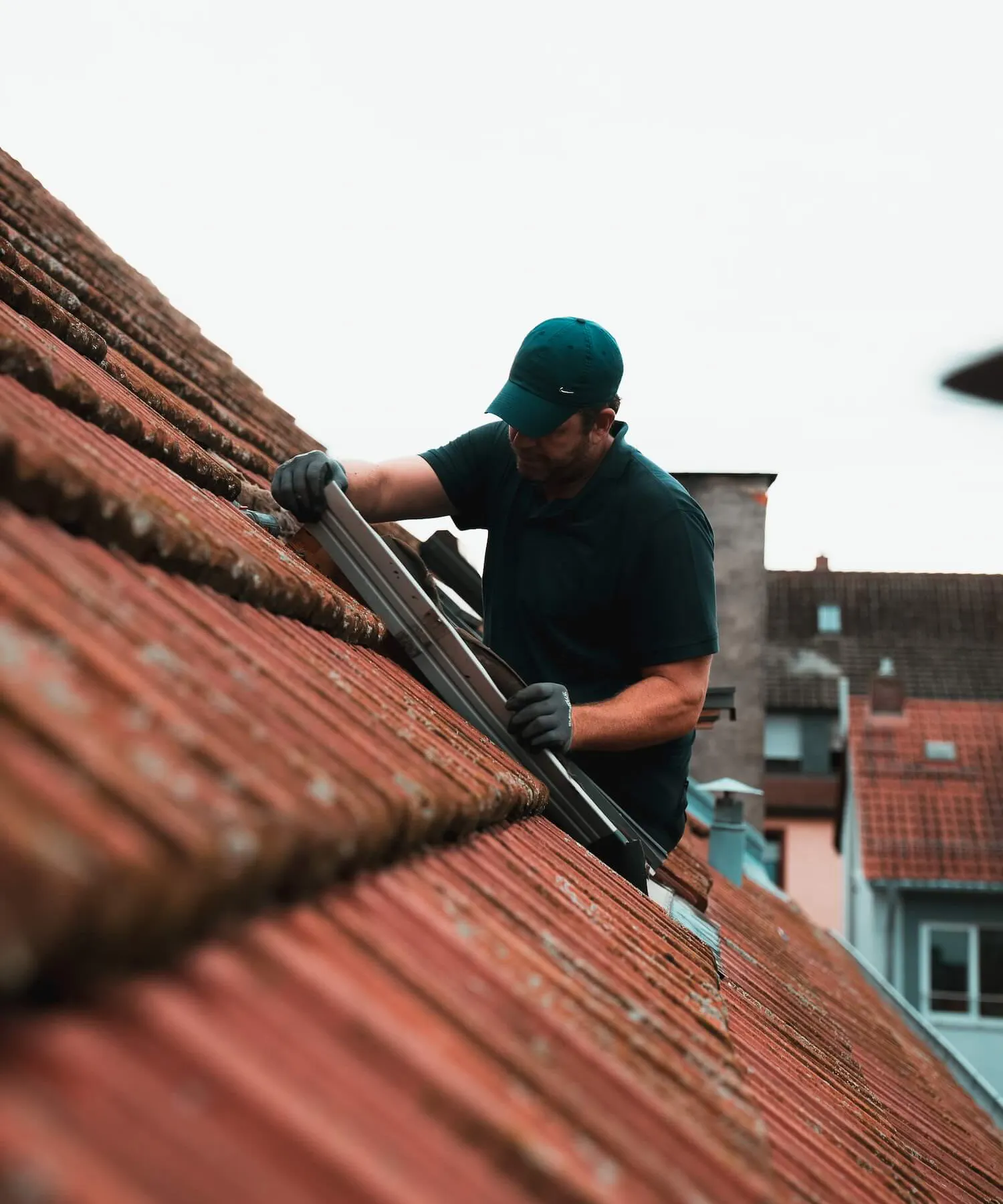 Lichtwunder Monteur beim Austausch eines Dachfensters auf einem roten Ziegeldach Lichtwunder Monteur beim Austausch eines Dachfensters auf einem roten Ziegeldach