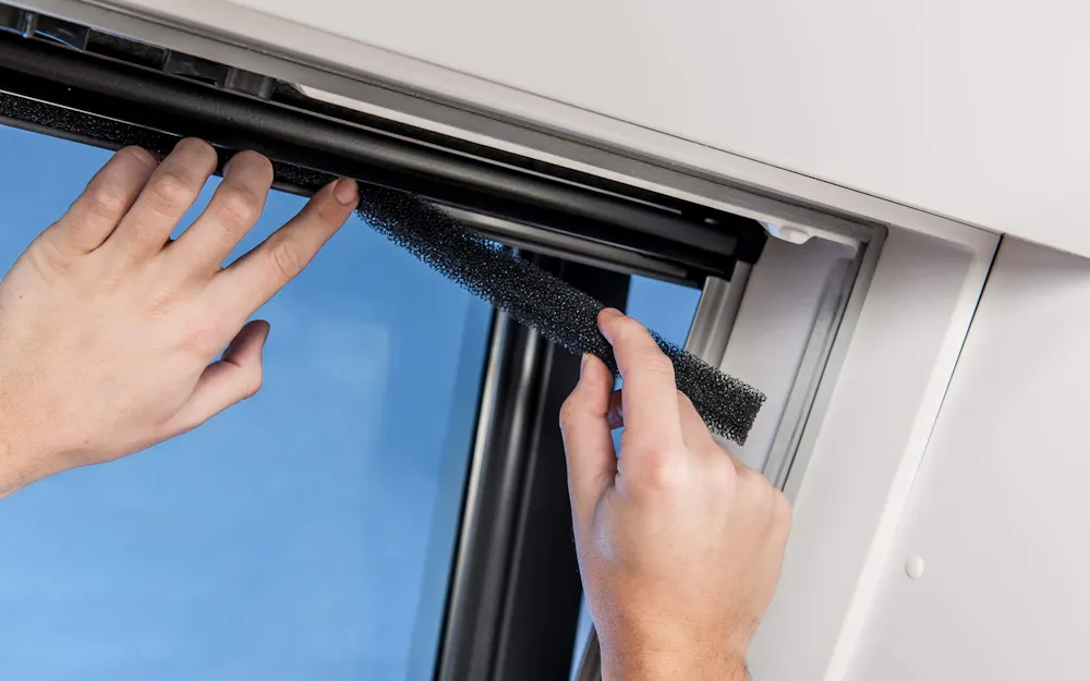 Person tausch Pollenschutz an Velux Dachfenster aus Person tausch Pollenschutz an Velux Dachfenster aus