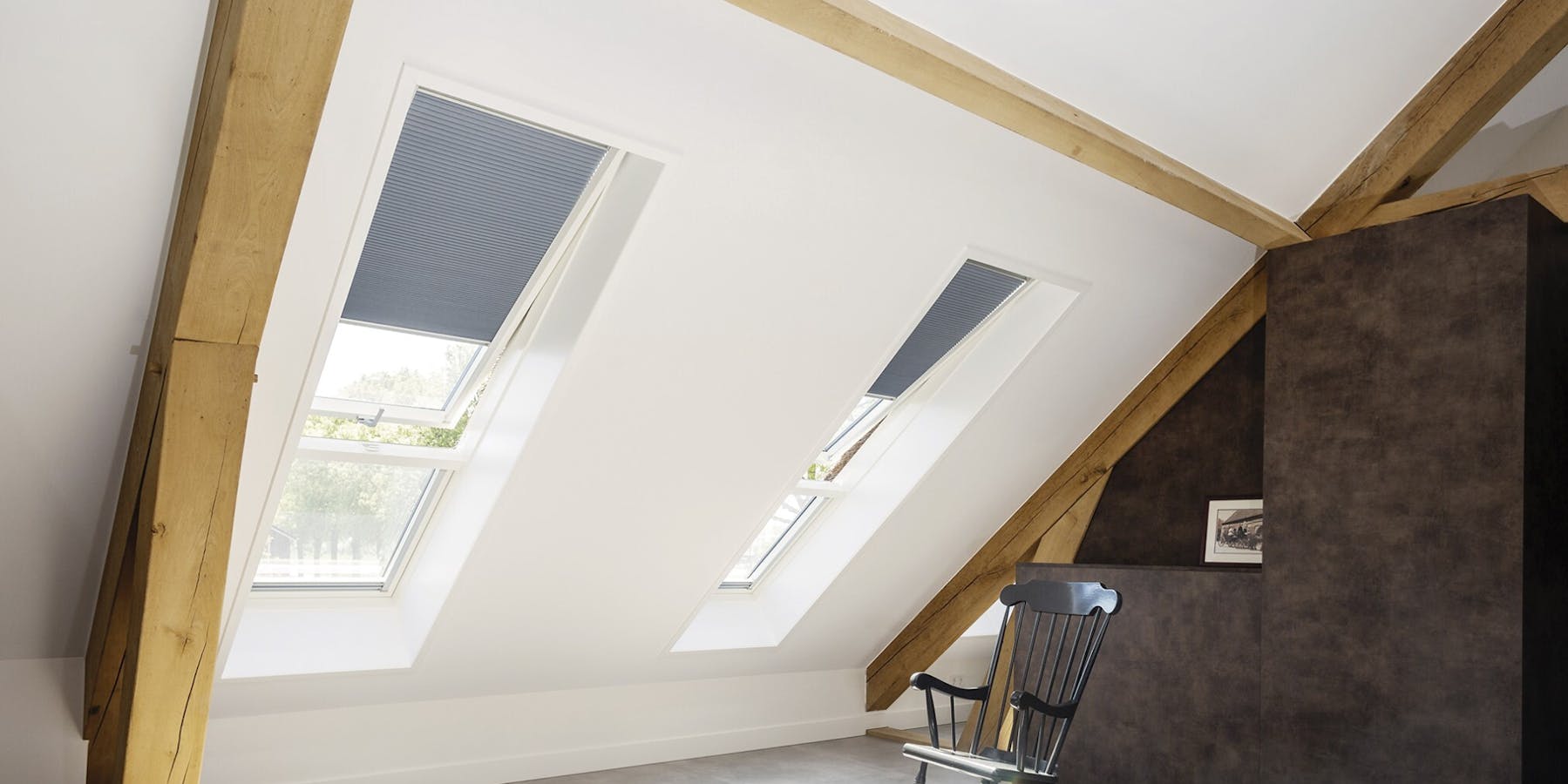 Zwei nebeneinanderliegende Dachfenster im Innenraum eines Dachgeschosses Zwei nebeneinanderliegende Dachfenster im Innenraum eines Dachgeschosses