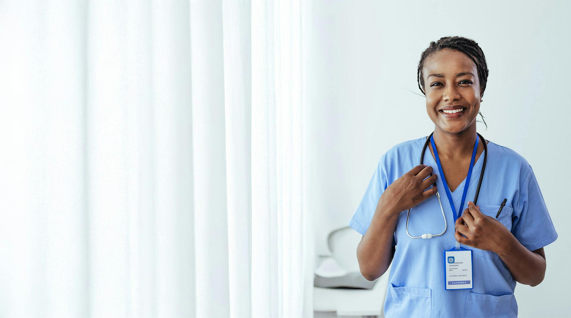 Pflegerin blickt lächelnd in die Kamera