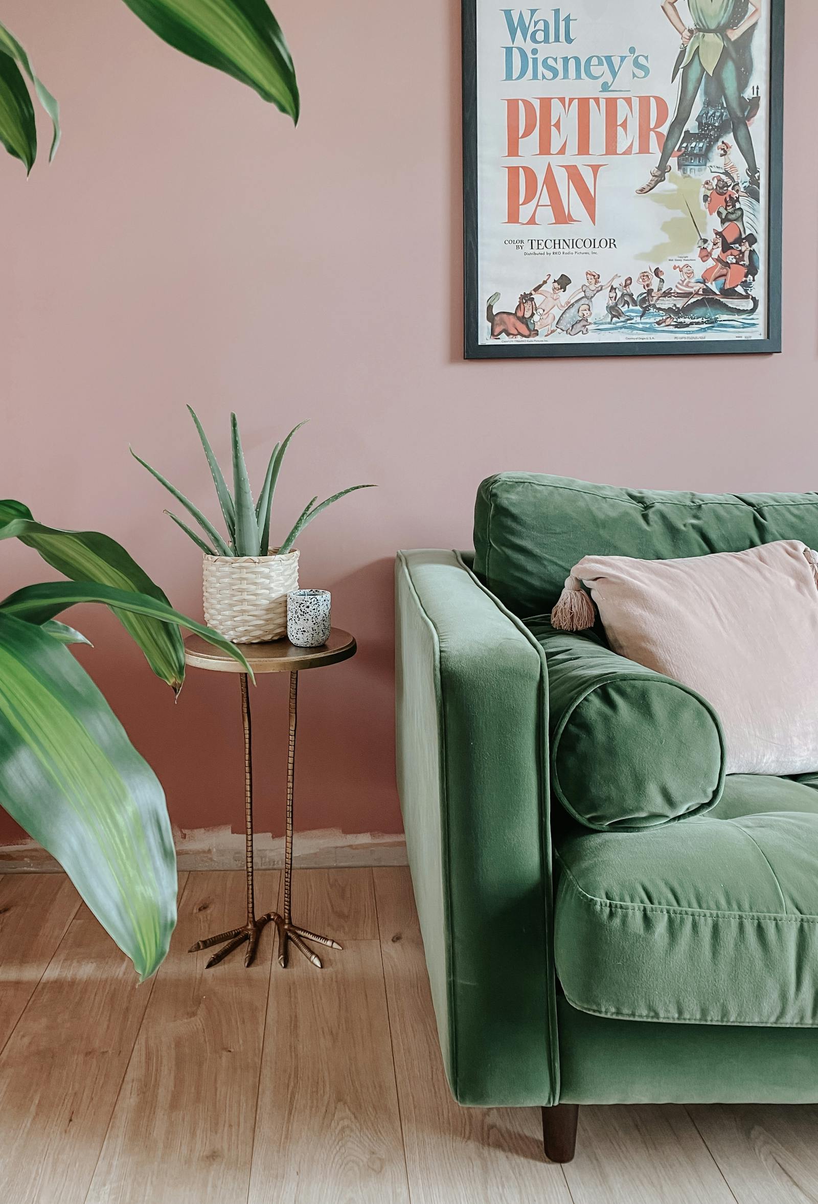 Green velvet sofa next to various plants