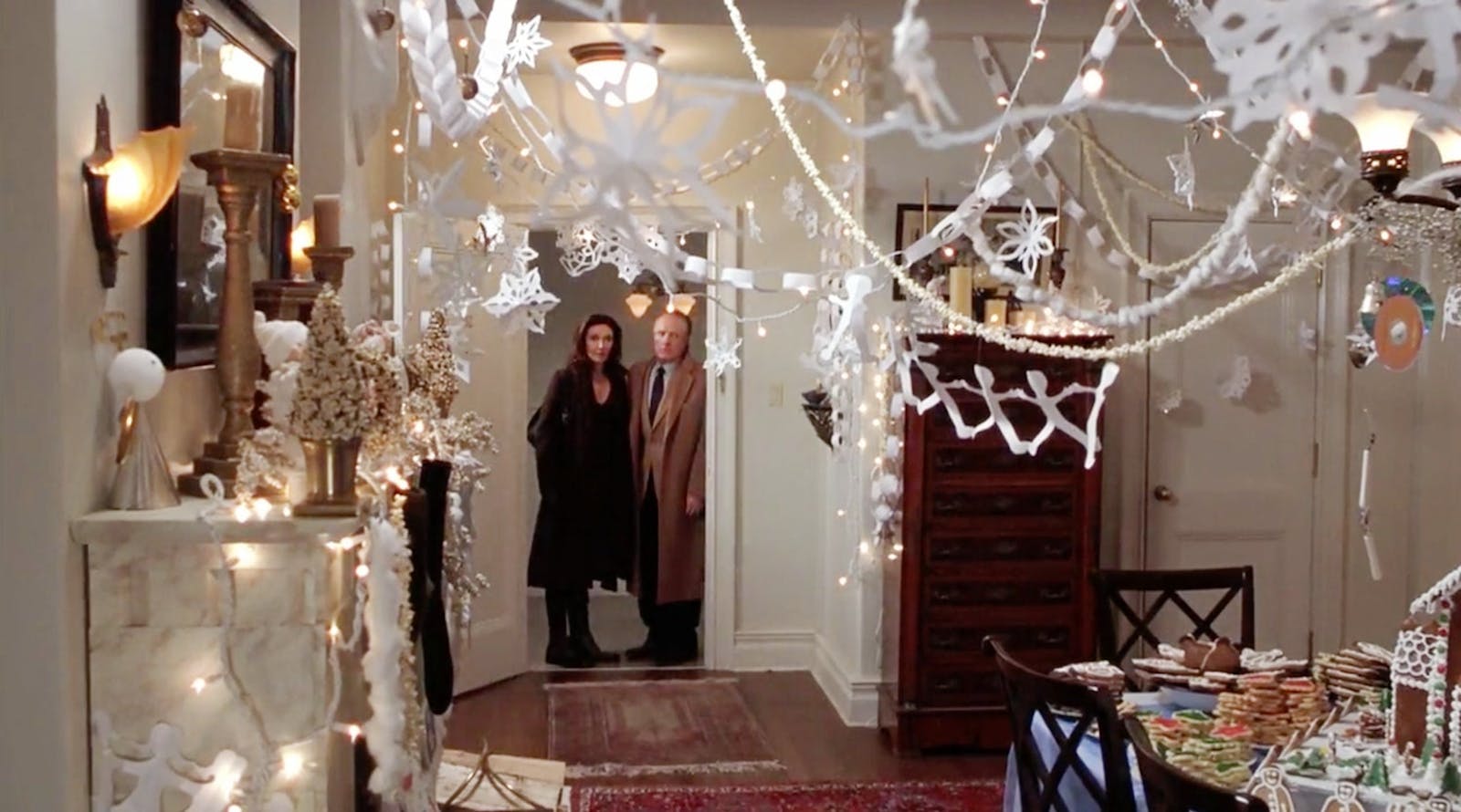 Man and woman looking into a room decorated in Christmas bunting, a famous scene in movie Elf