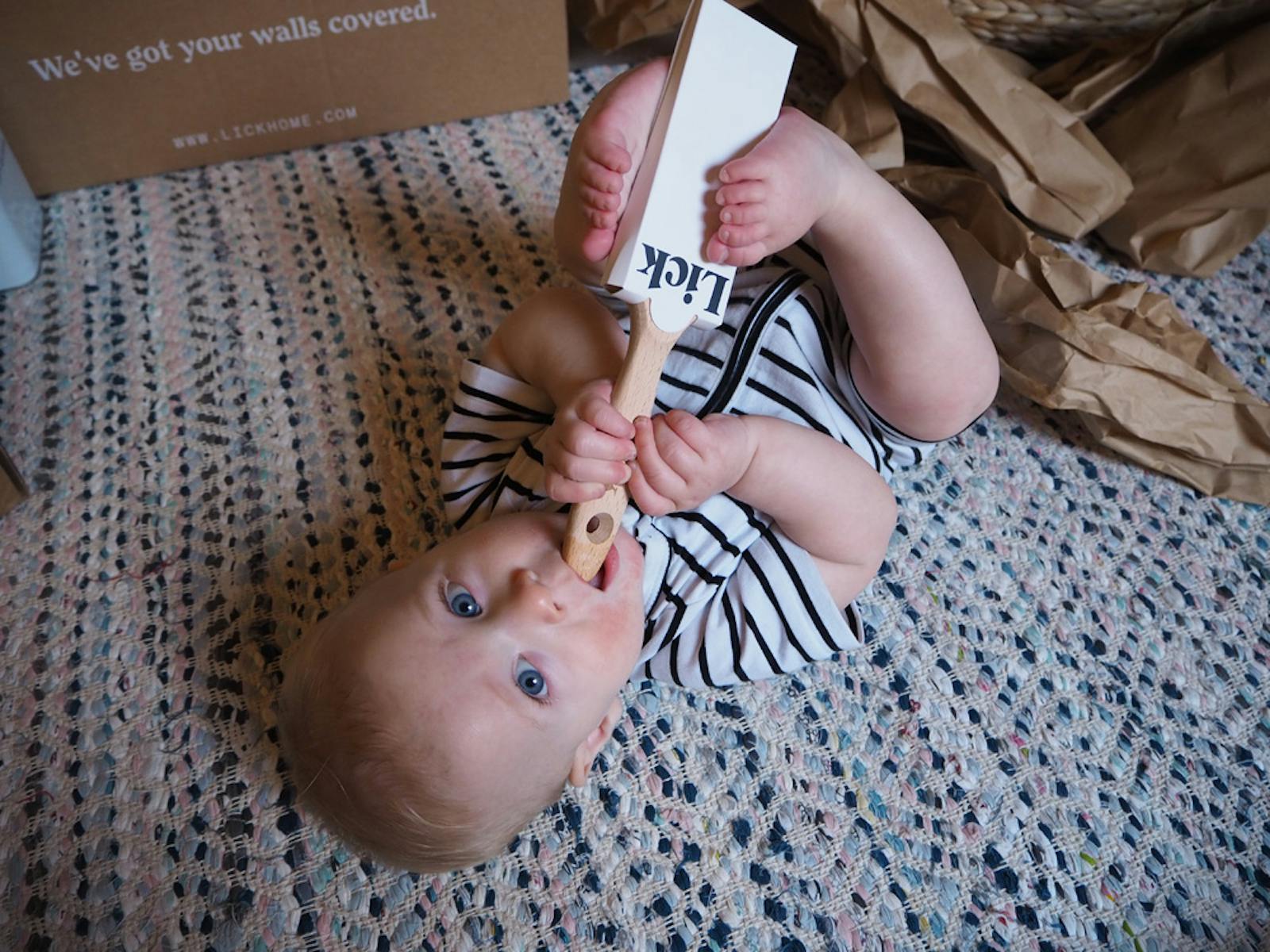 A baby chewing on an unused Lick paint brush