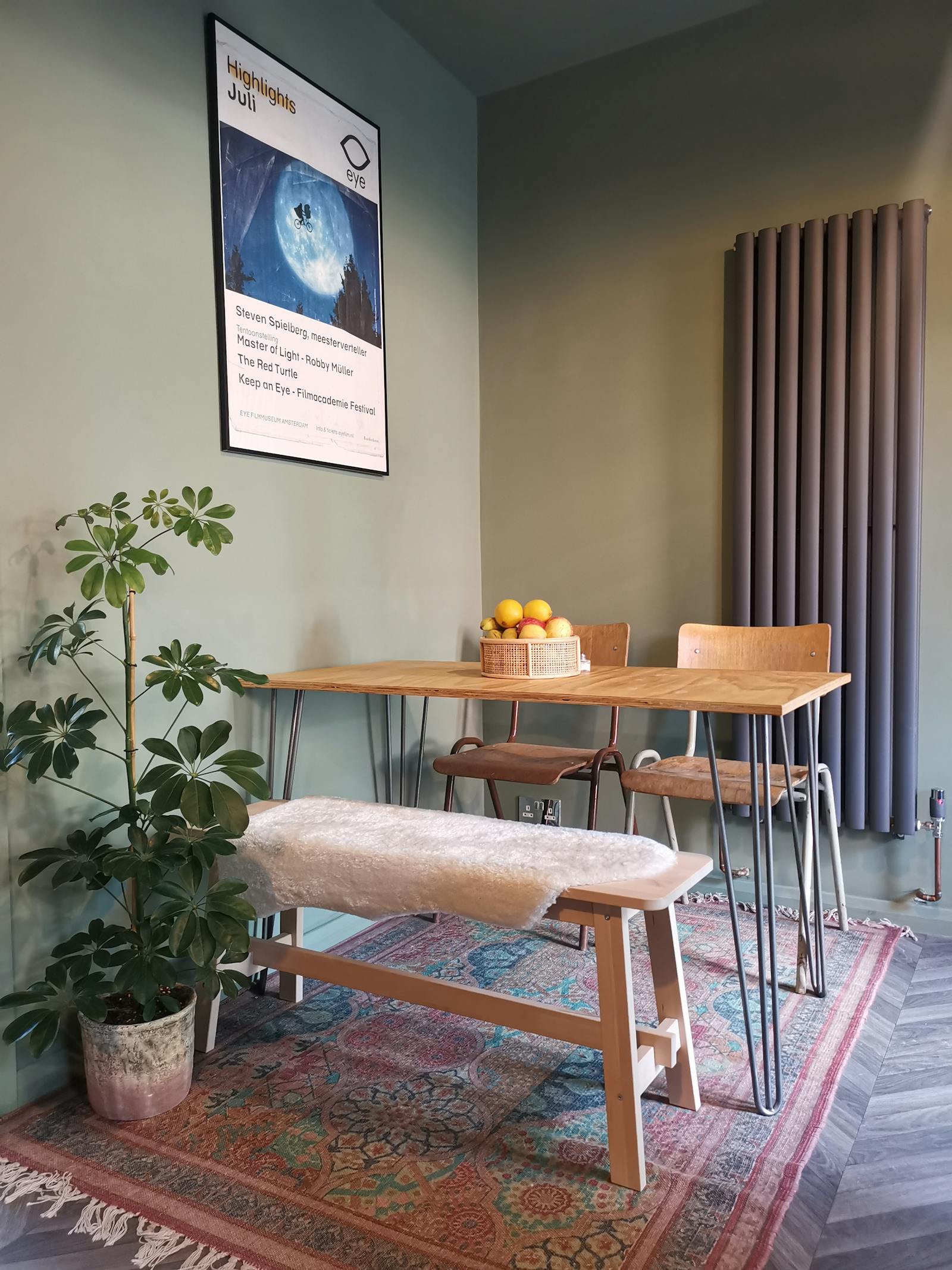 Dining space painted in light green, with wooden chairs and wooden table