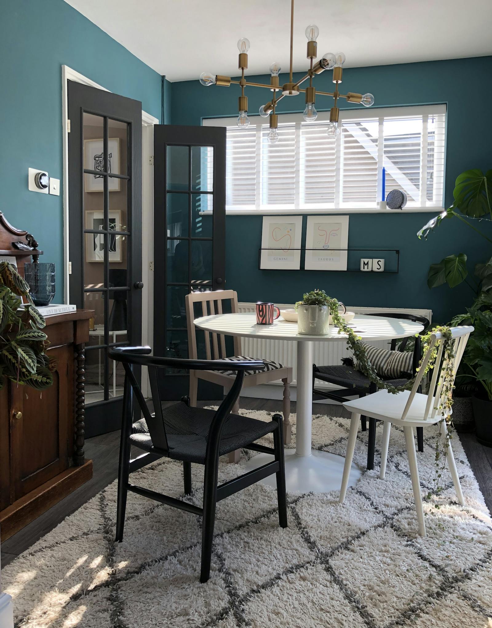 Dining area with teal blue walls and berber-style rug