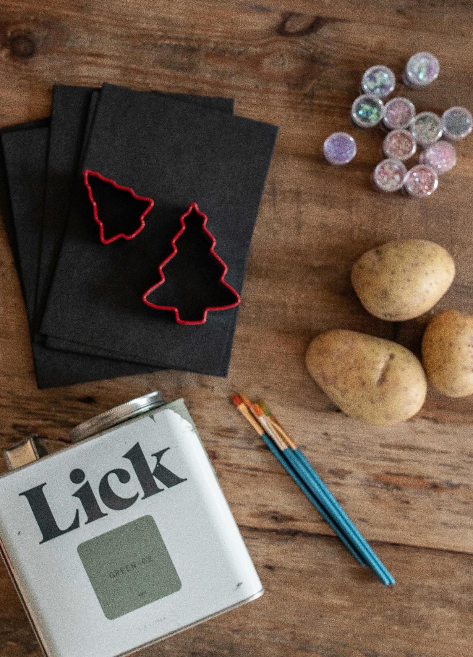 Lick paint tin next to potatoes and cookie cutters