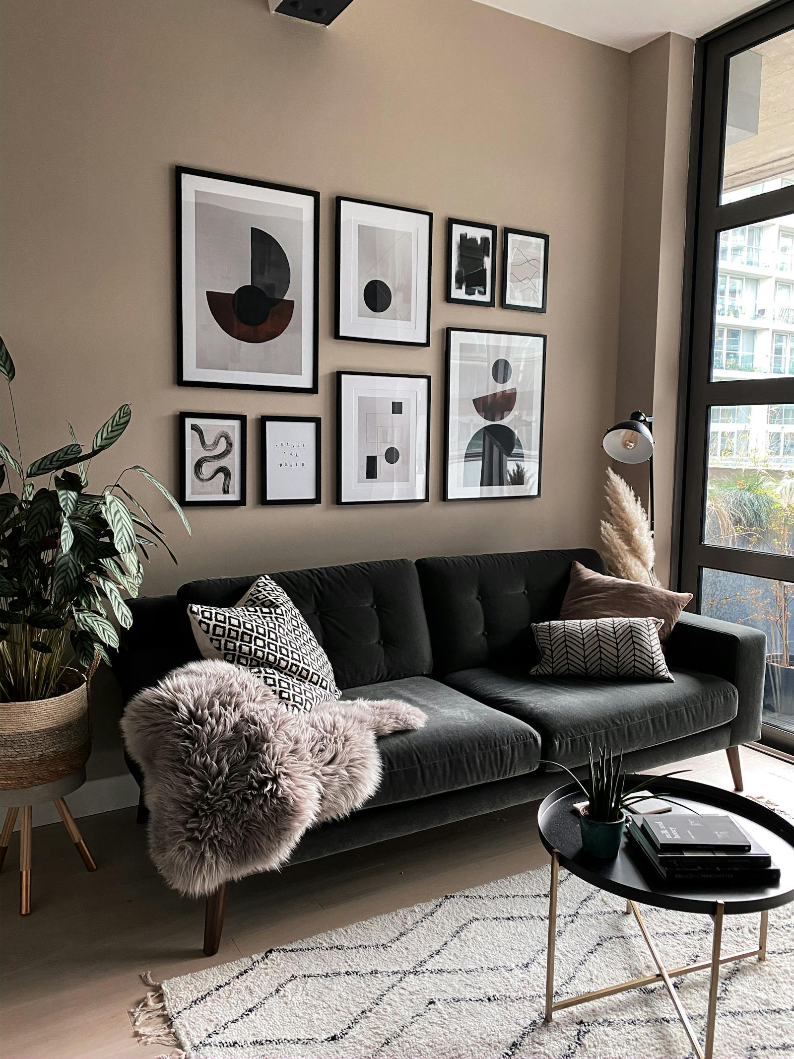 Living room with a dark sofa in front of a beige gallery wall