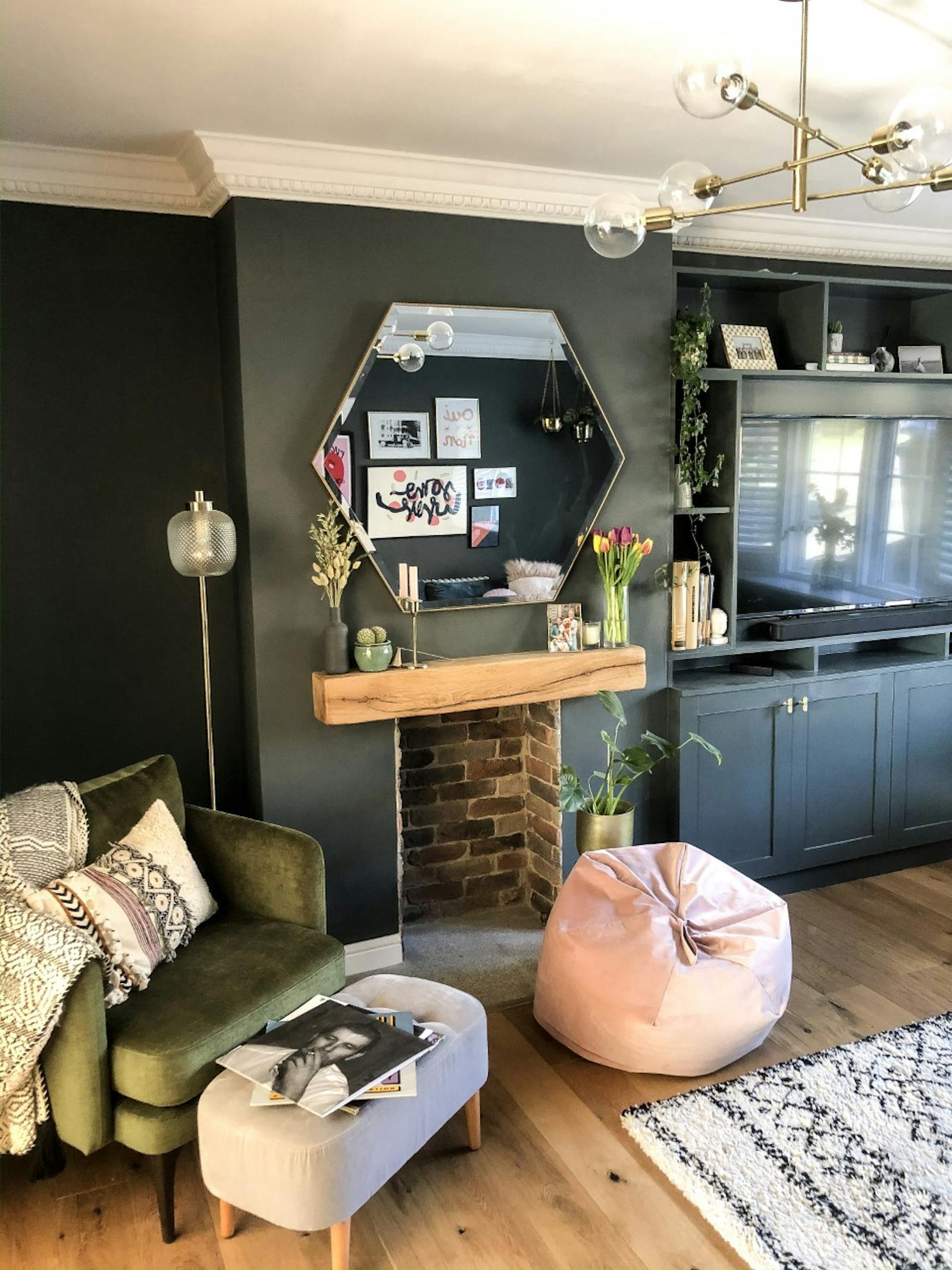 Living room painted in dark teal with armchair and soft furnishings
