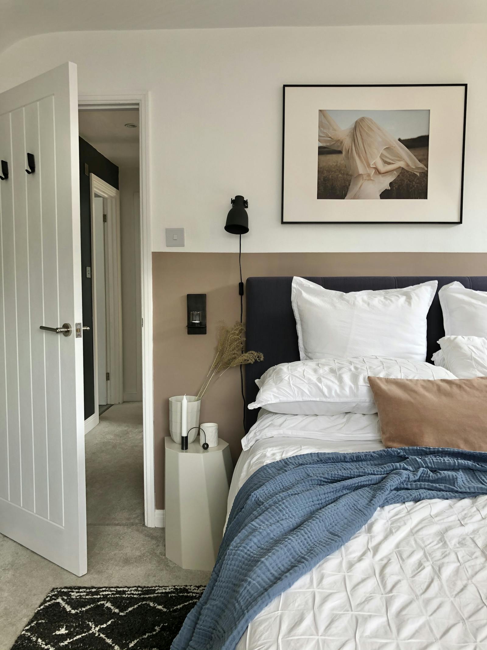 Master bedroom with neutral and white walls and white bedding on bed