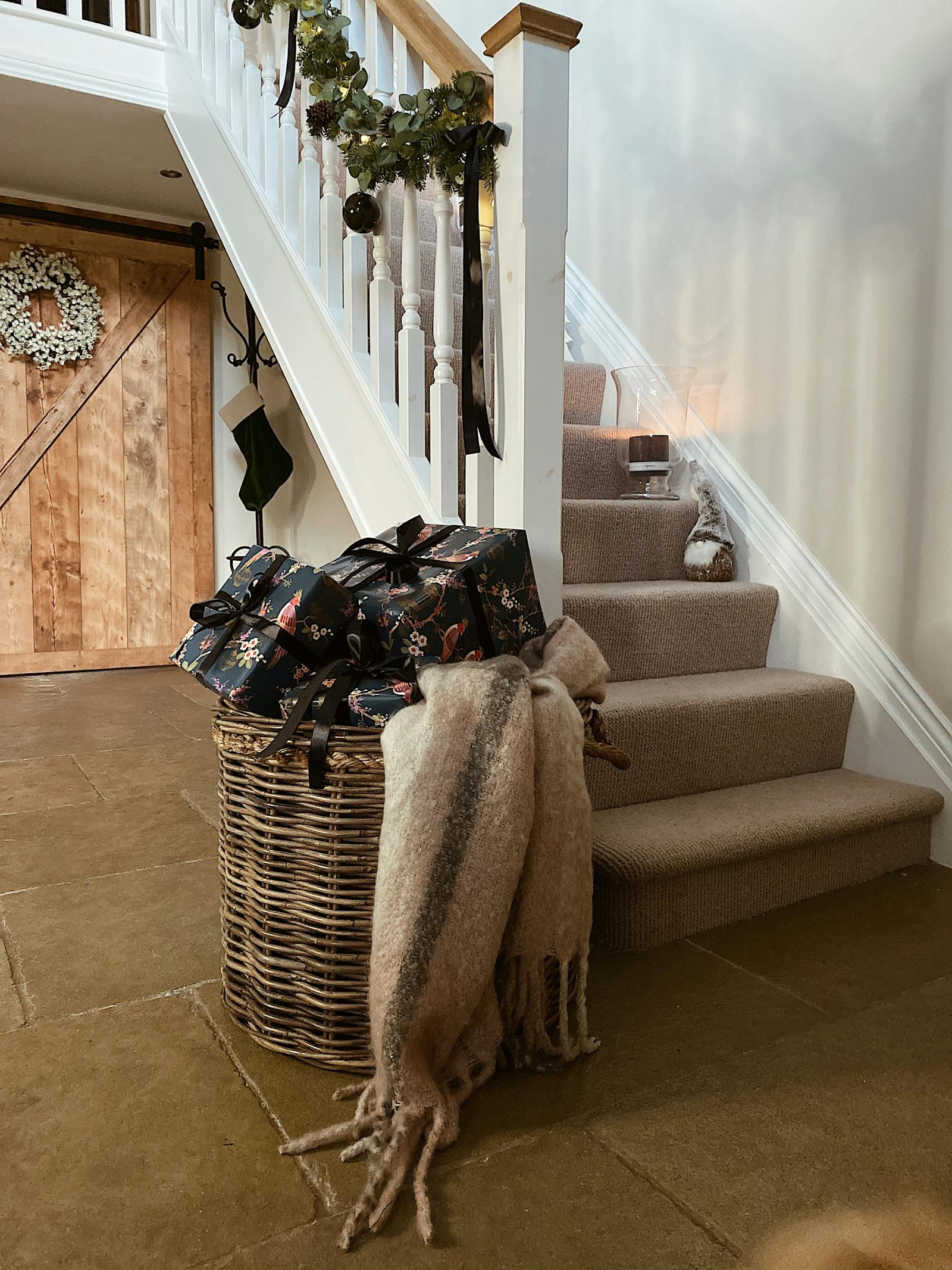 Hallway with big woven basket with gifts and fresh foliage on the stairwell