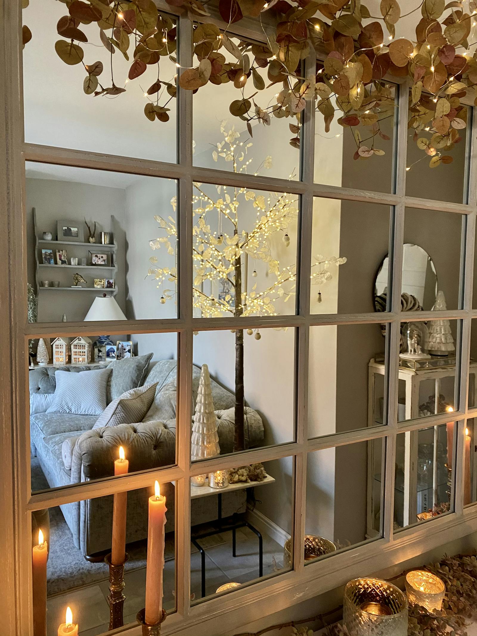 Wall mirror reflecting a Christmas decorated living room