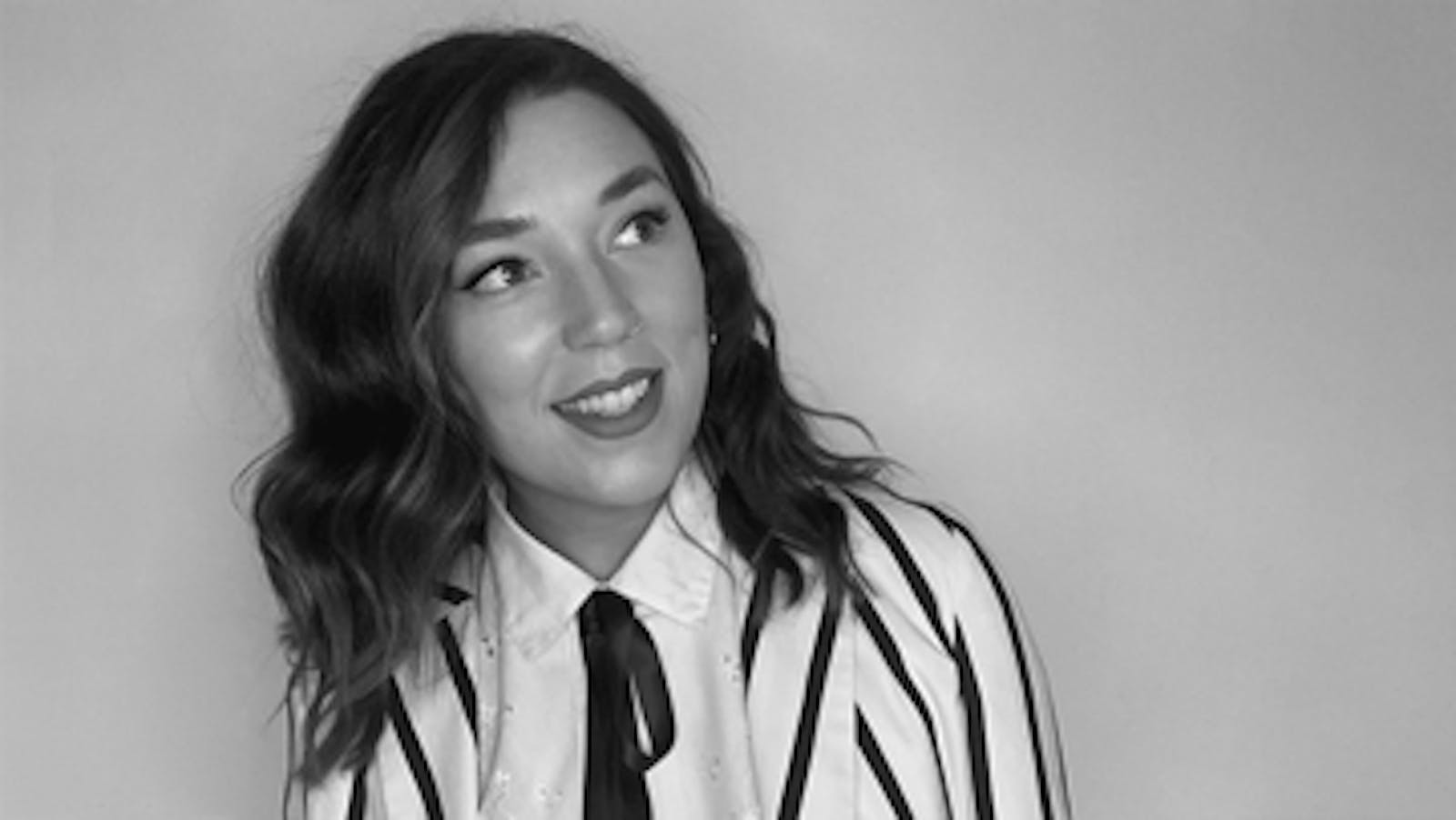 Artist (Lottie) smiling in black and white picture