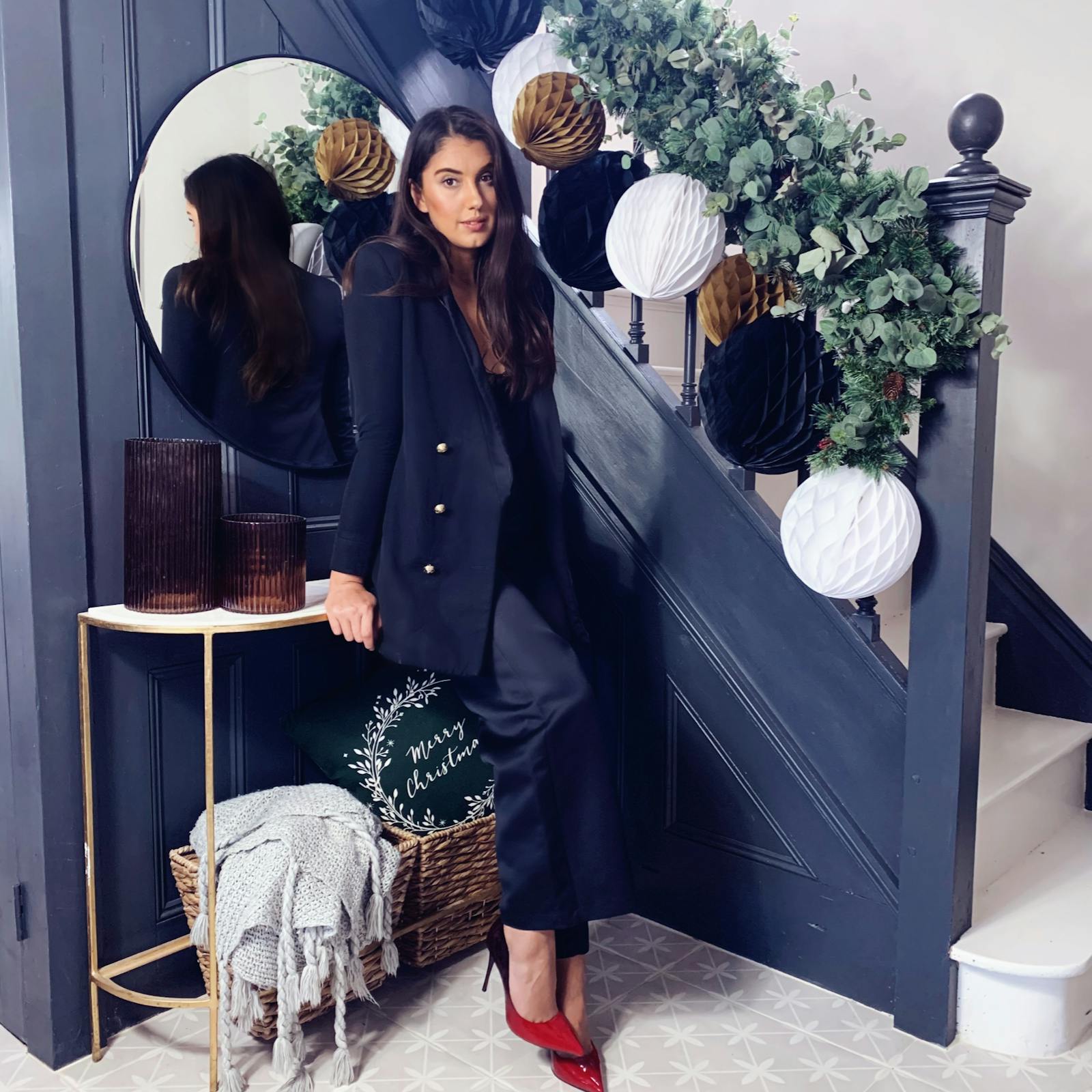 Woman posing in front of staircase decorated in Christmas decoration