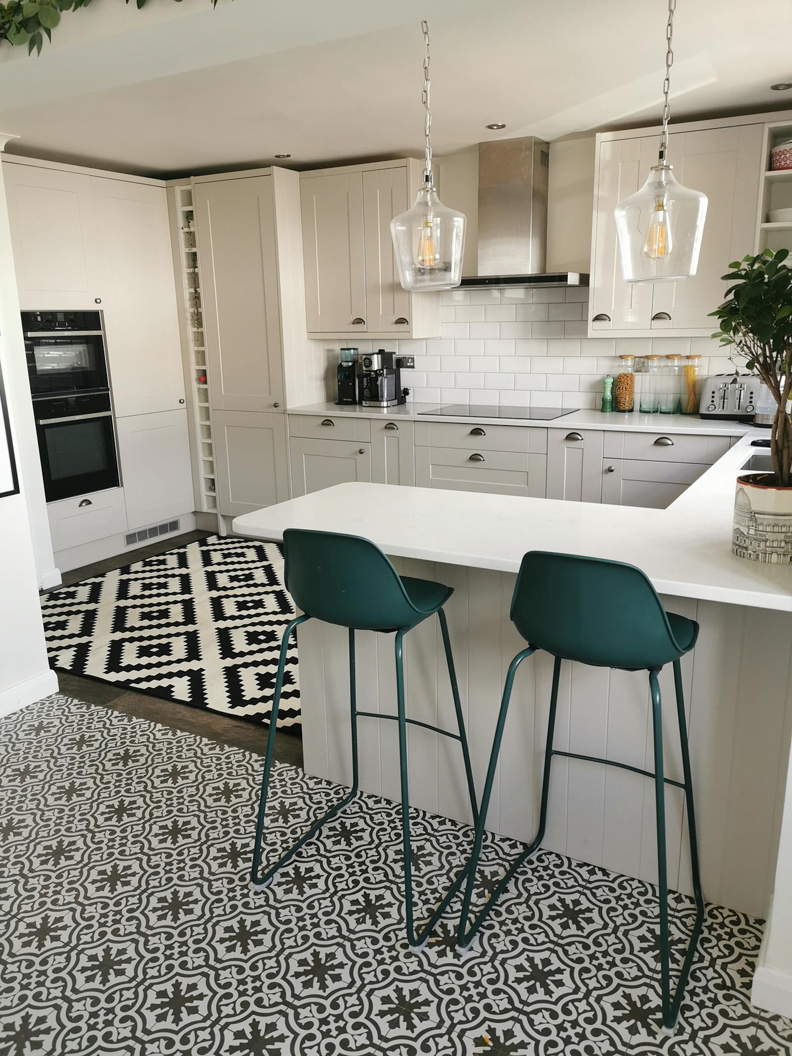 kitchen area with tall chairs and different patterned rugs