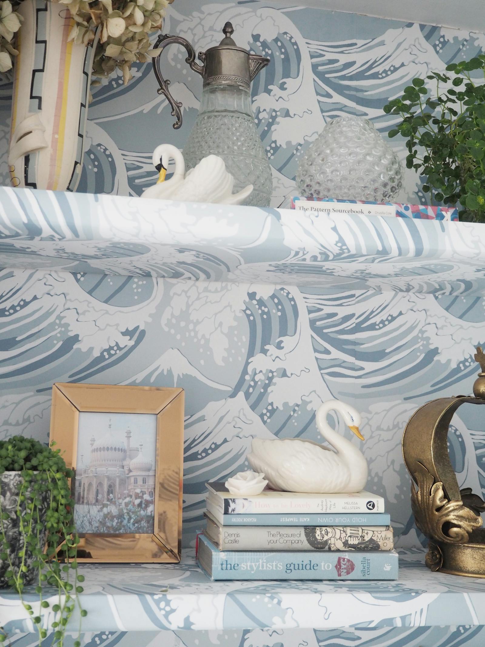 Bookshelf with books and various swan ornaments