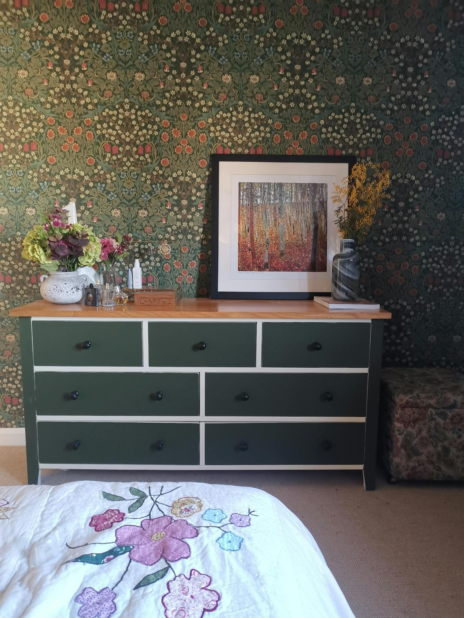 bedroom with a patterned floral wallpaper and flowers around