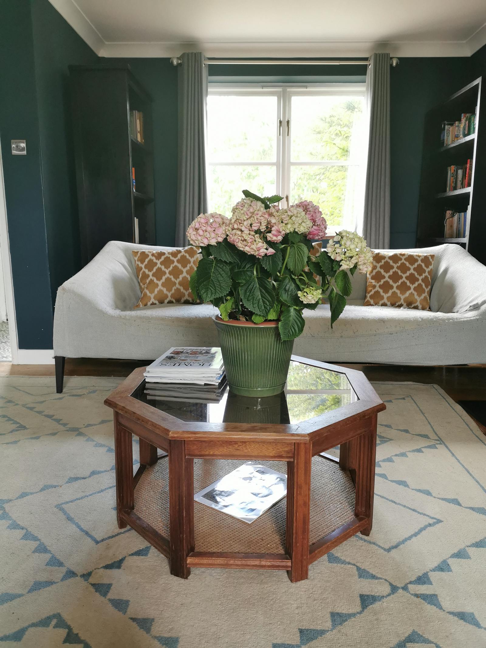 living room with a patterned carpet and grey sofa