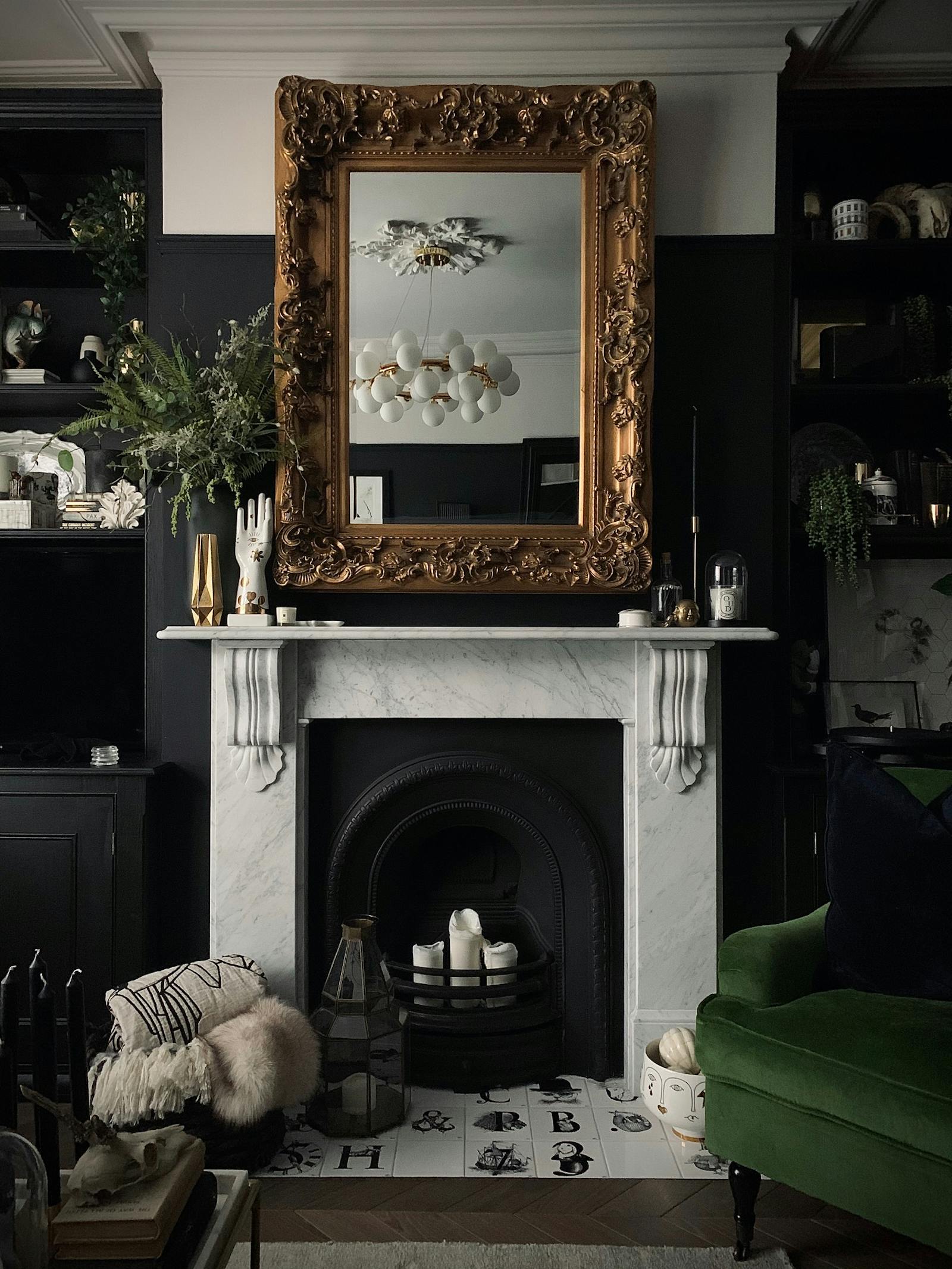 Fireplace with a big vintage mirror reflecting on the lamps on the ceiling