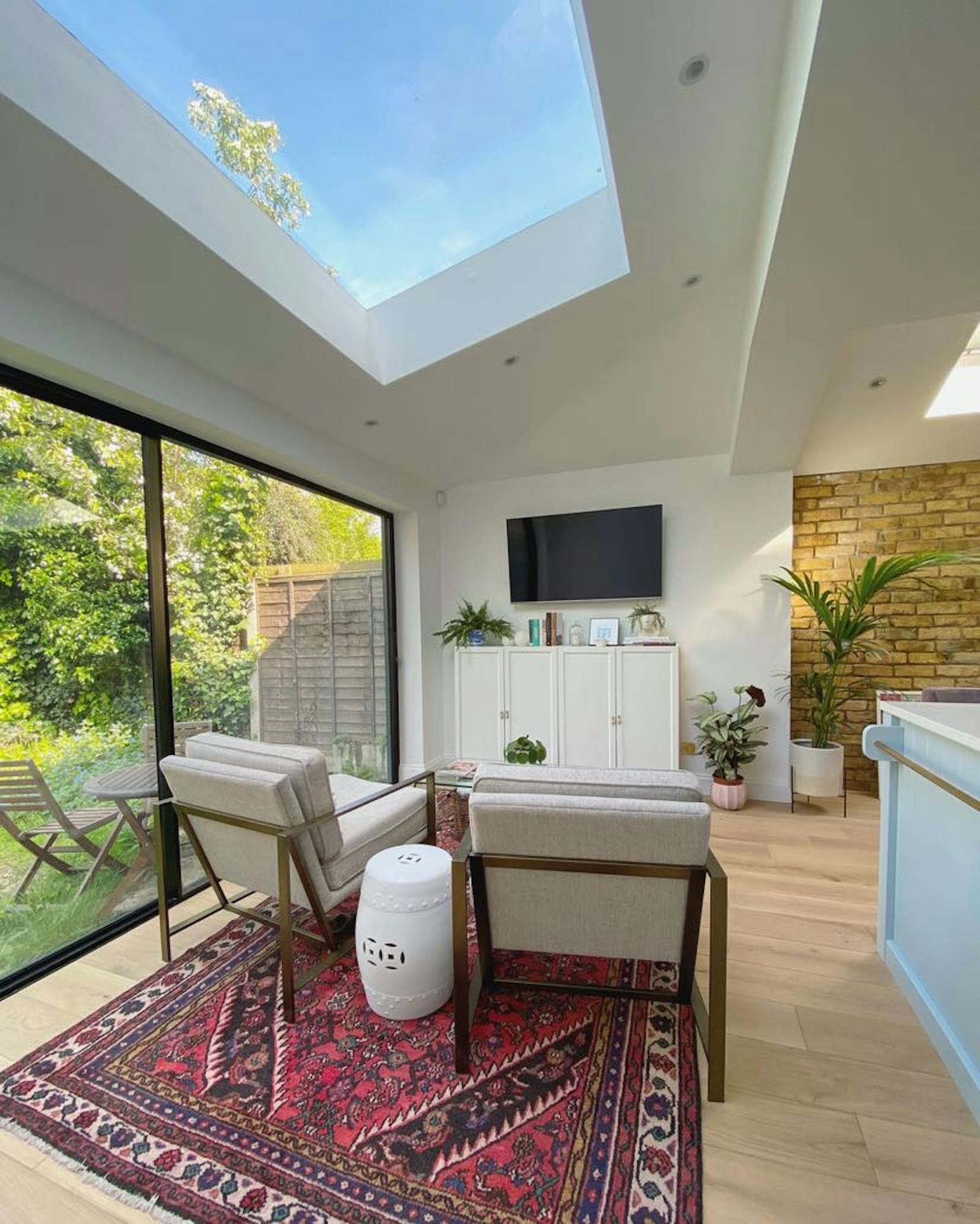 Lounge area with two chairs, red carpet and a tv