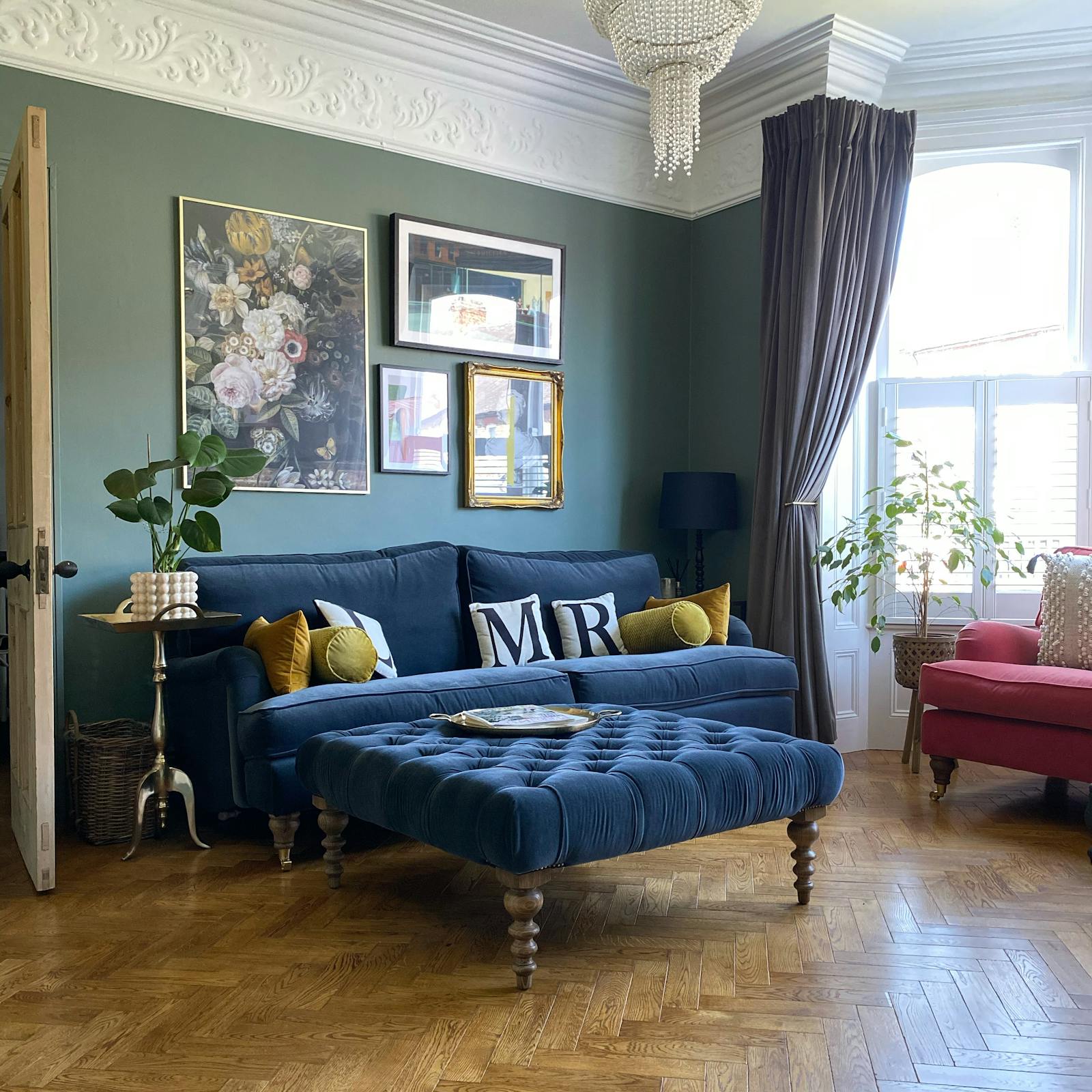 Living room with a sage green wall and a navy sofa