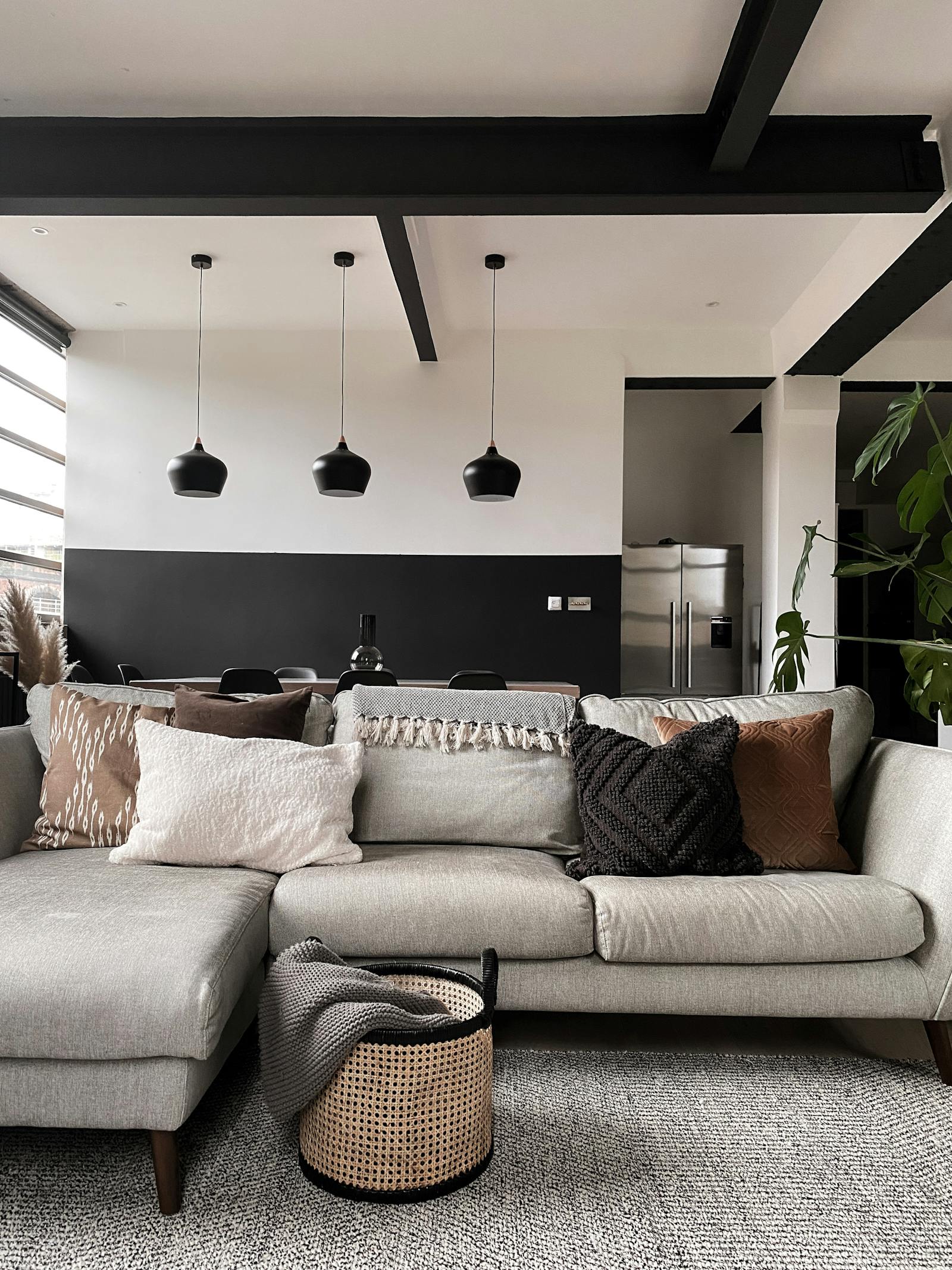 Living room with a grey sofa and an open plan dining area behind it