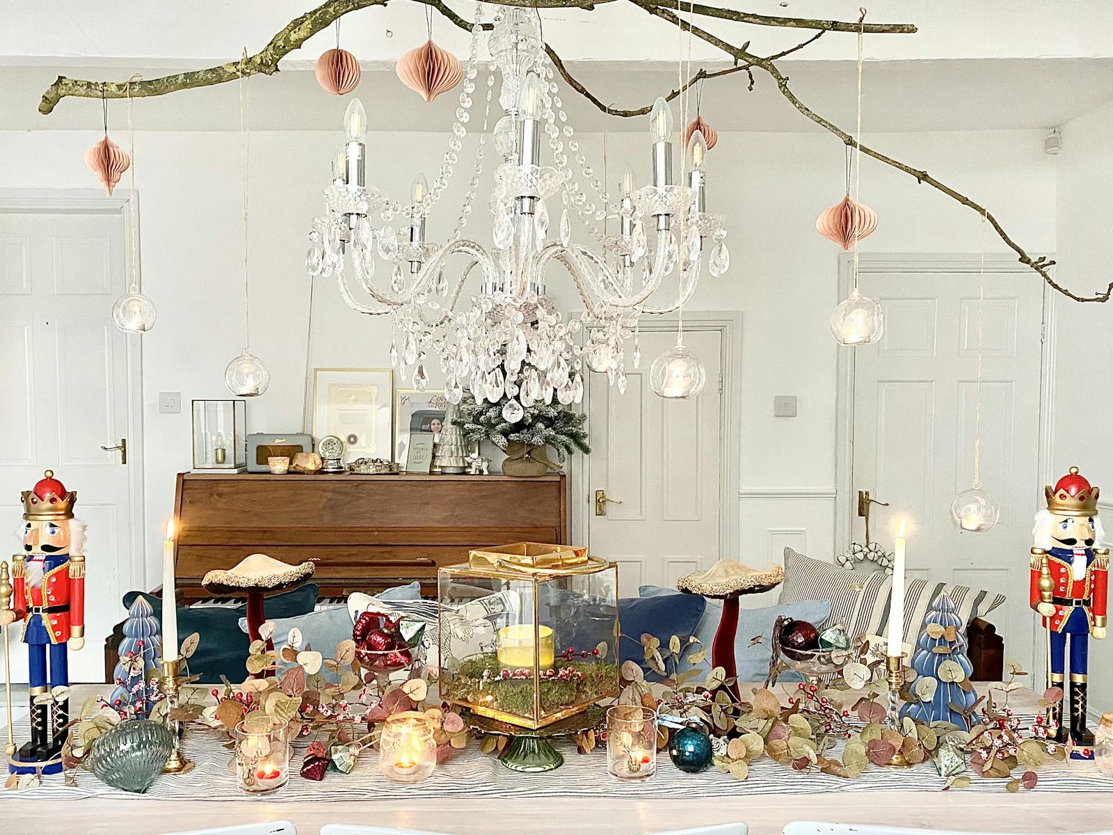 Dining table decked in Christmas decorations with large crystal chandelier