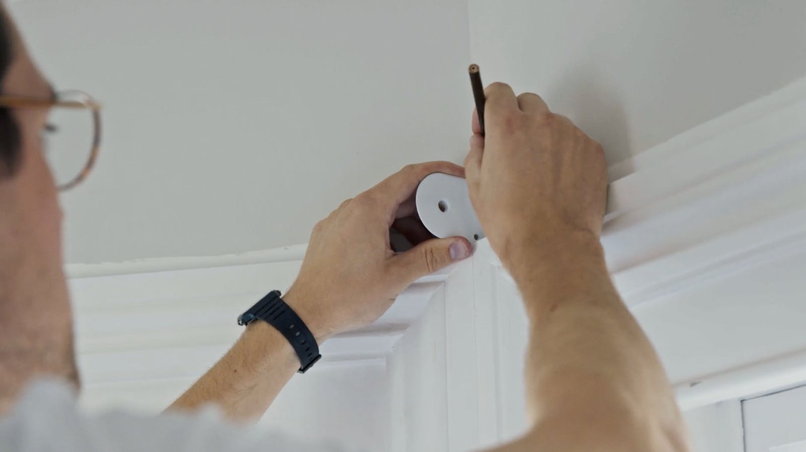 Man holding bracket and pencil
