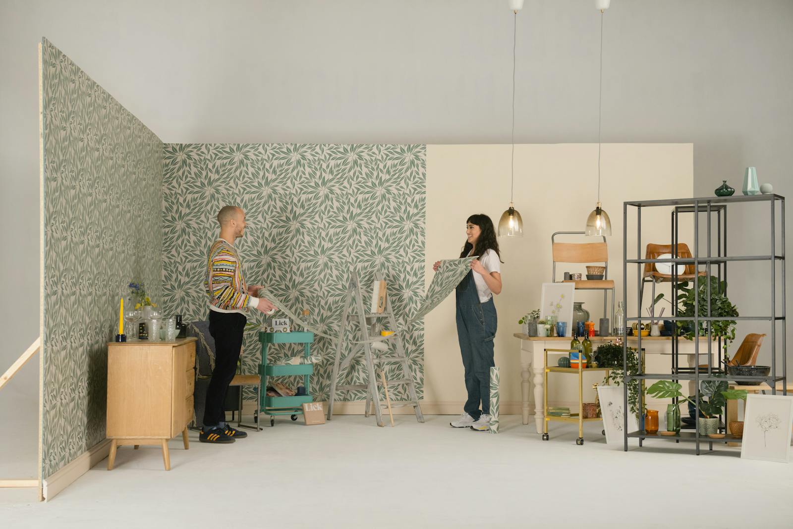 Man and woman holding a sheet of botanical Lick wallpaper