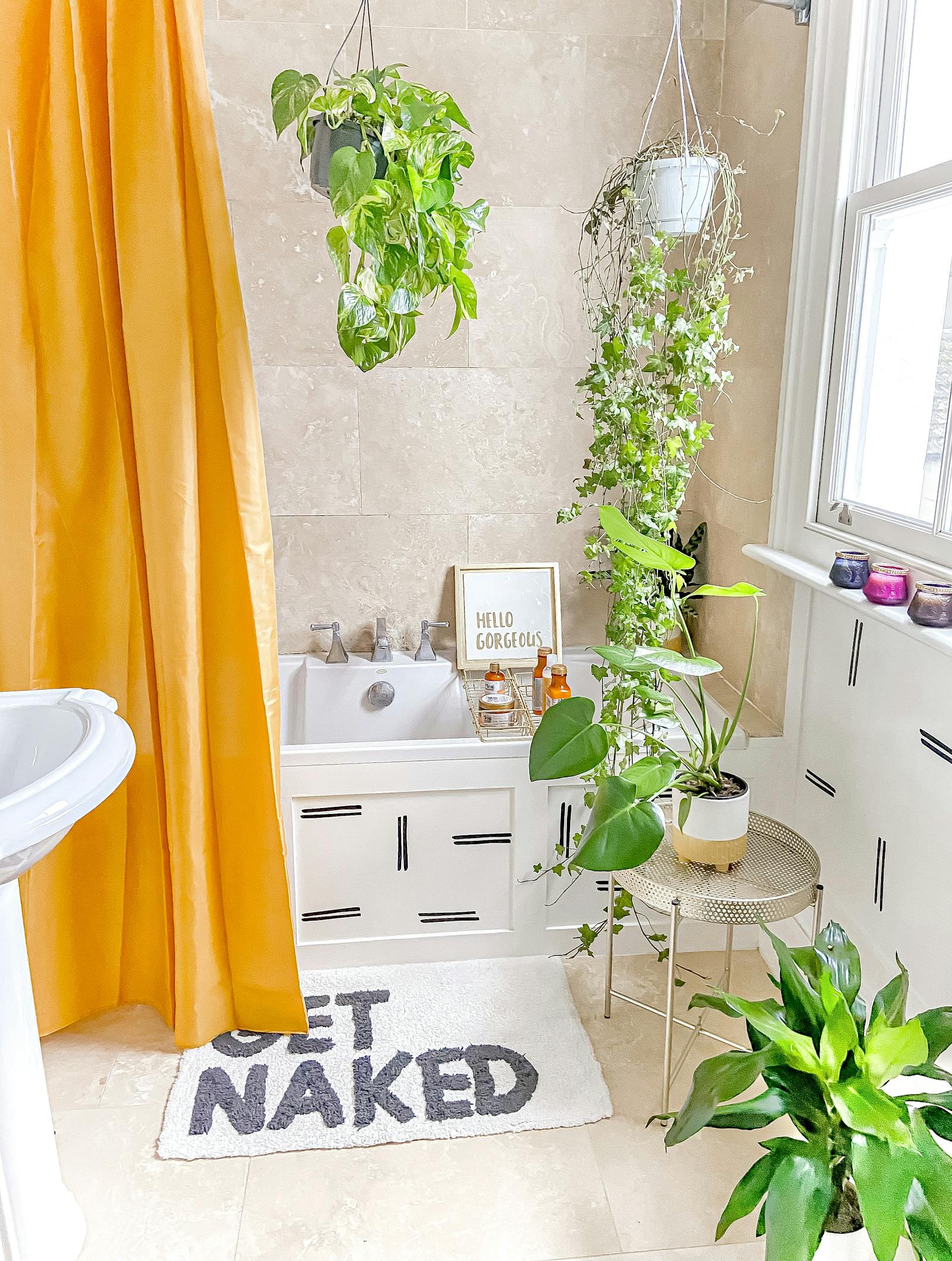 Brightly coloured bathroom with bright orange shower curtain and hanging plants