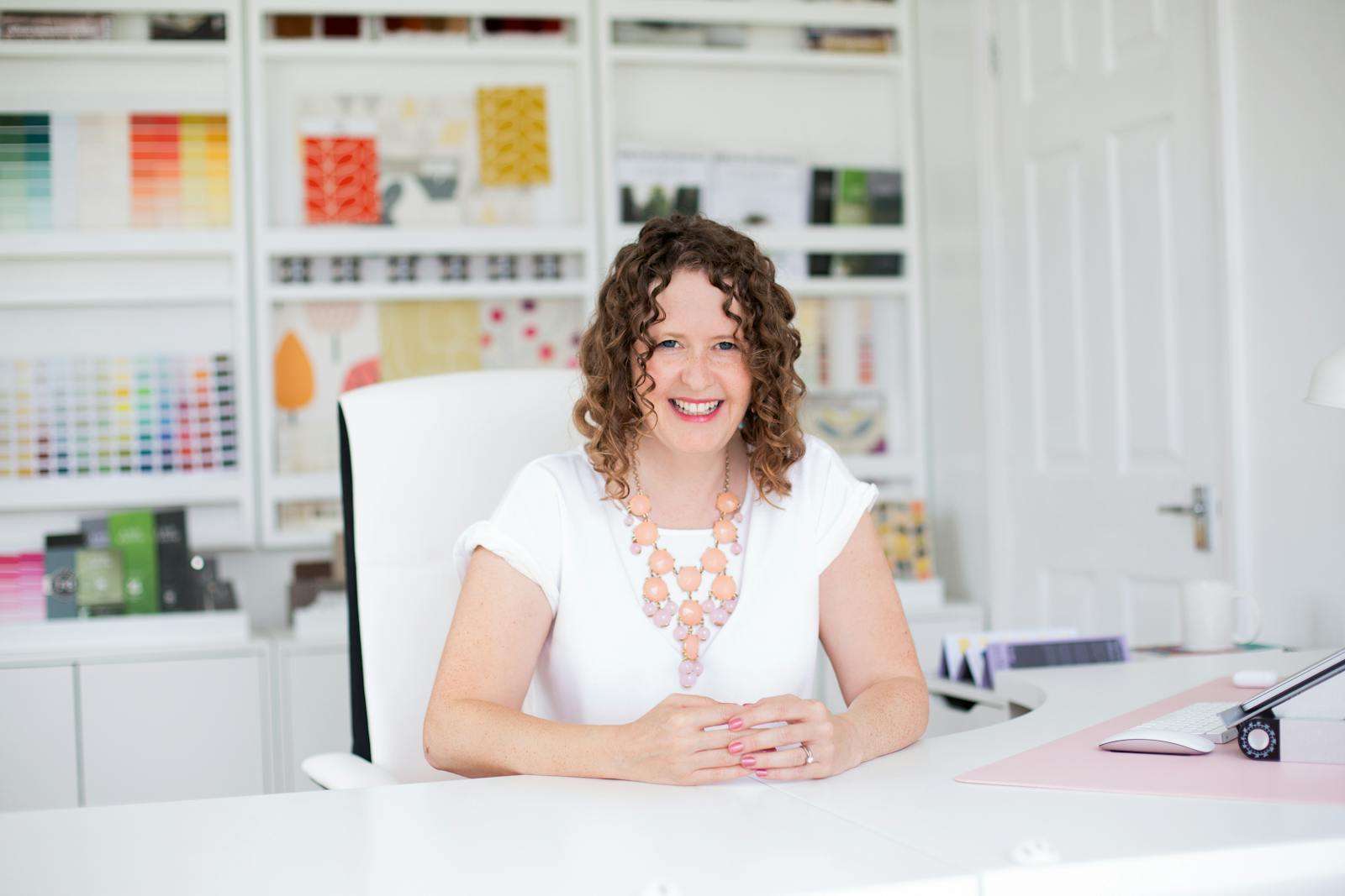 Woman sat at a desk smiling