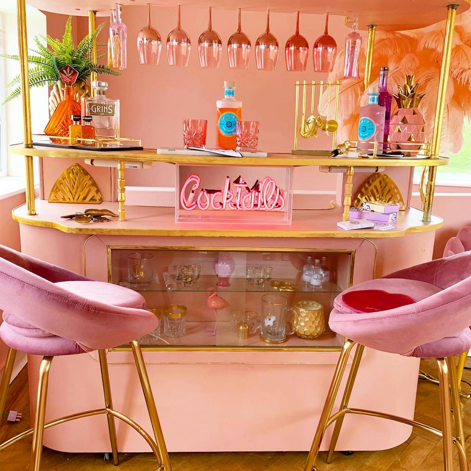 Retro-inspired cocktail bar in pink with plush chairs