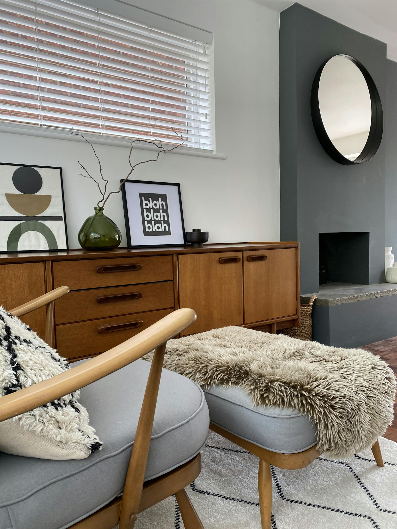 Living room with a vintage wooden cabinet and grey armchair