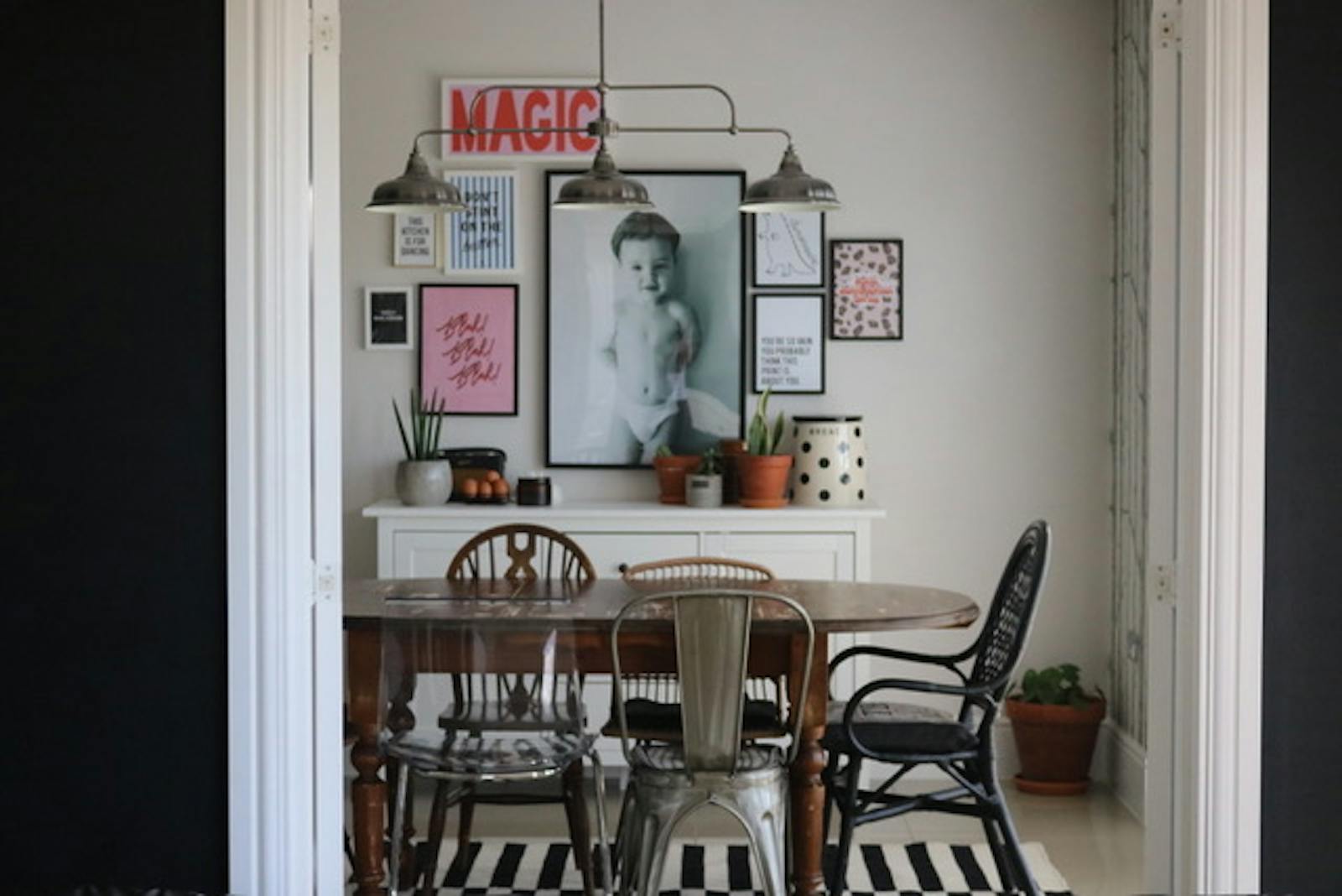 Dining table with photos and posters placed on the wall behind it