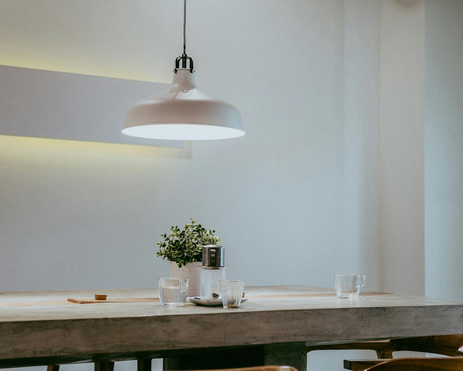 White dining room with solid wood dining table in minimalistic setting