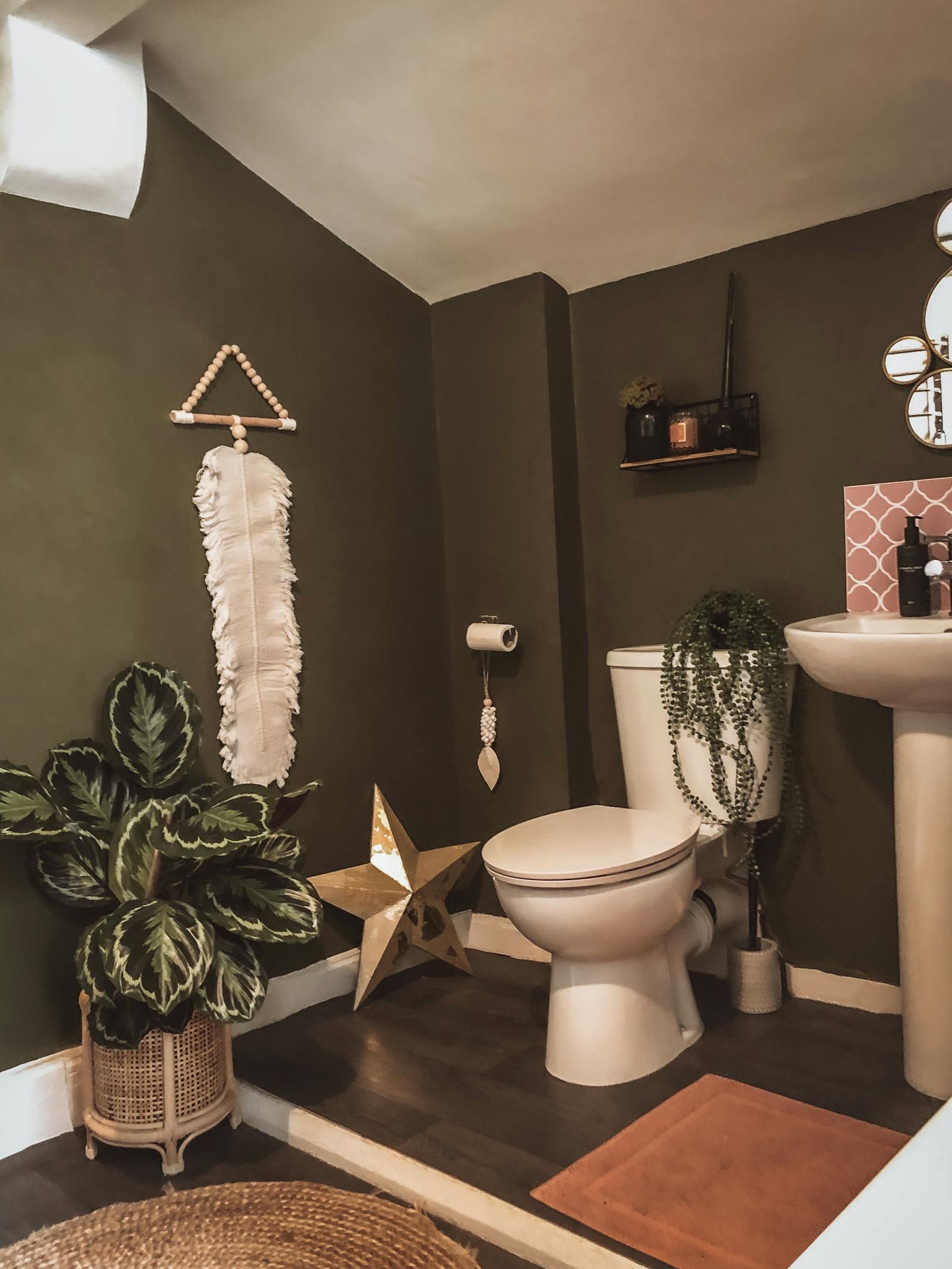Toilet painted in dark green with textured details and plants