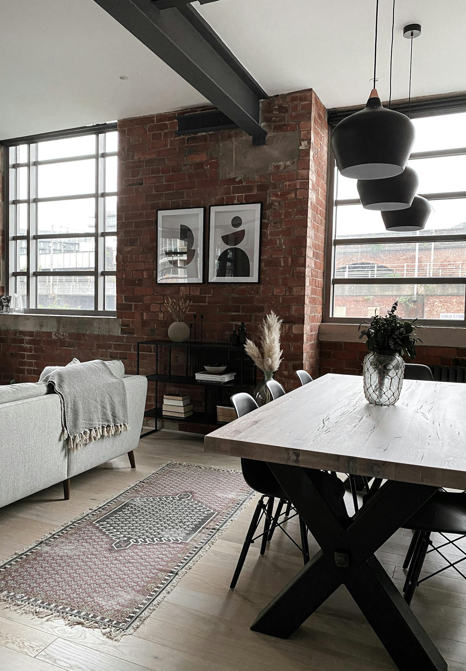 Open space living and dining room with an exposed brick wall