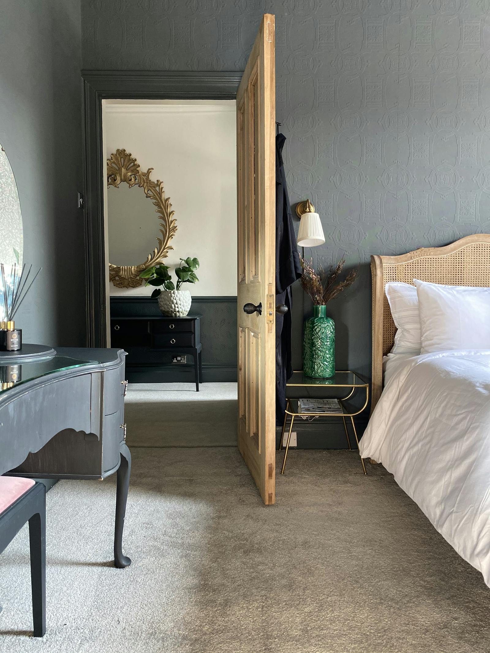 Open wooden door leading to a bedroom in medium grey colour