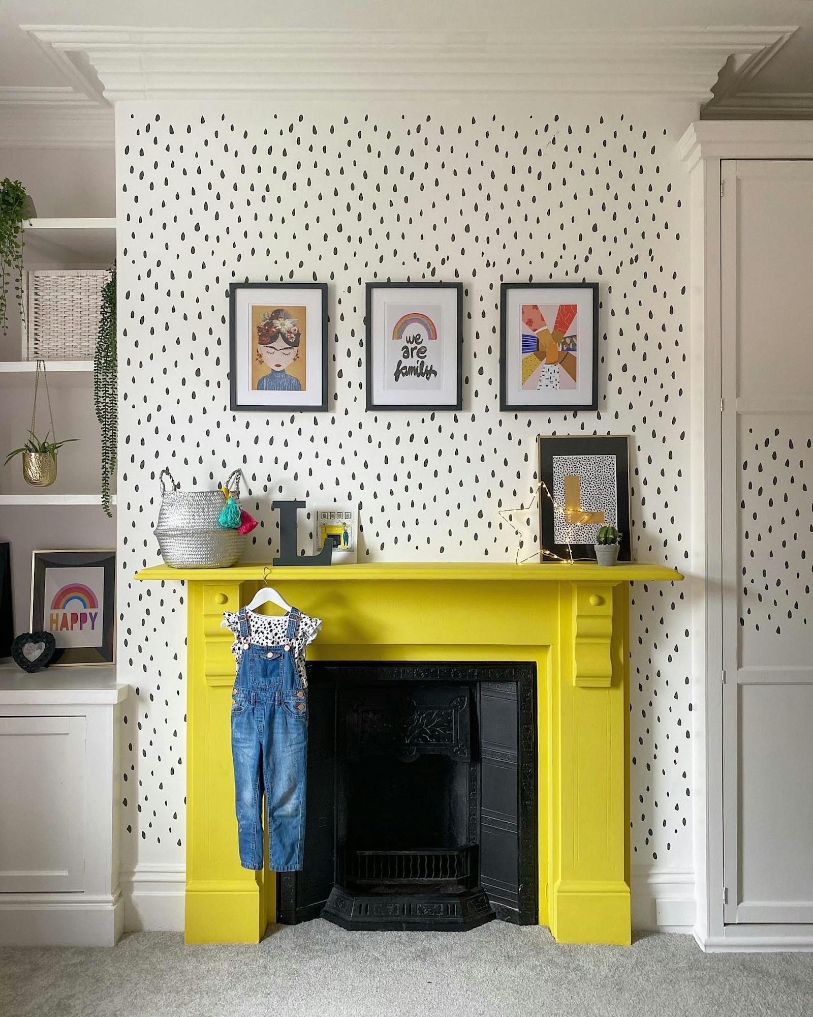Patterned wall with wall art and a fireplace painted in yellow
