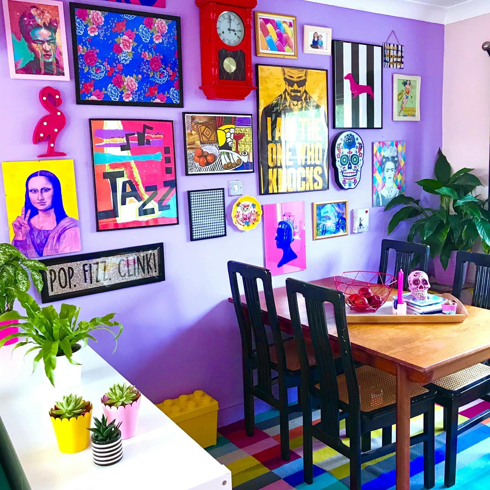 Purple dining room with a mix of prints on the wall