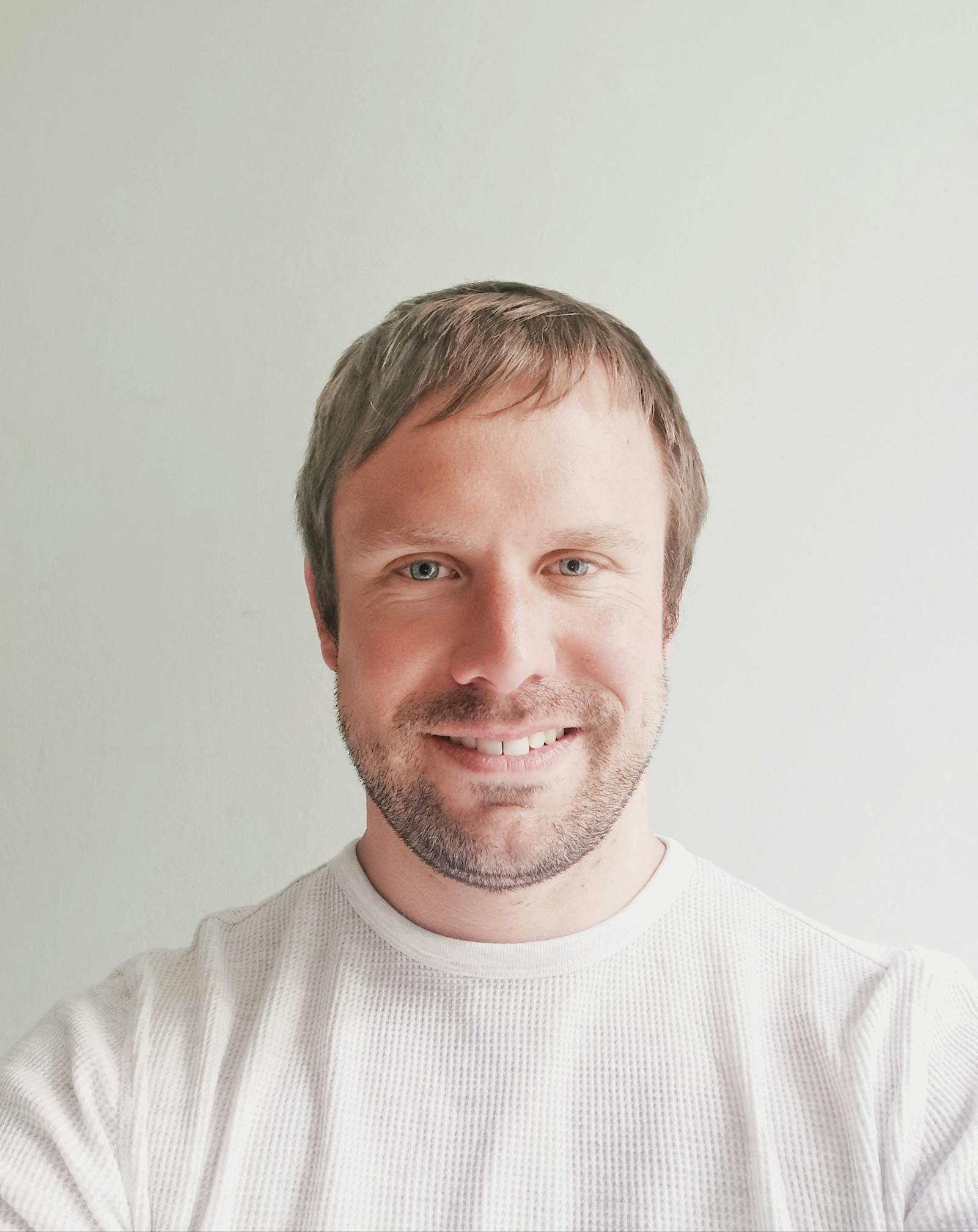 Man in a white jumper looking at the camera