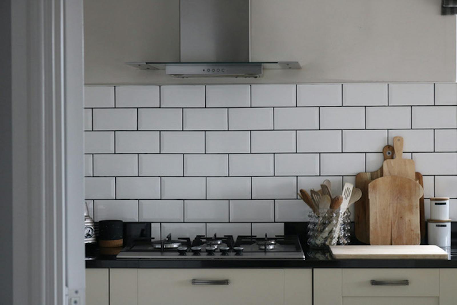 Close up of a kitchen with white tiles on the wall