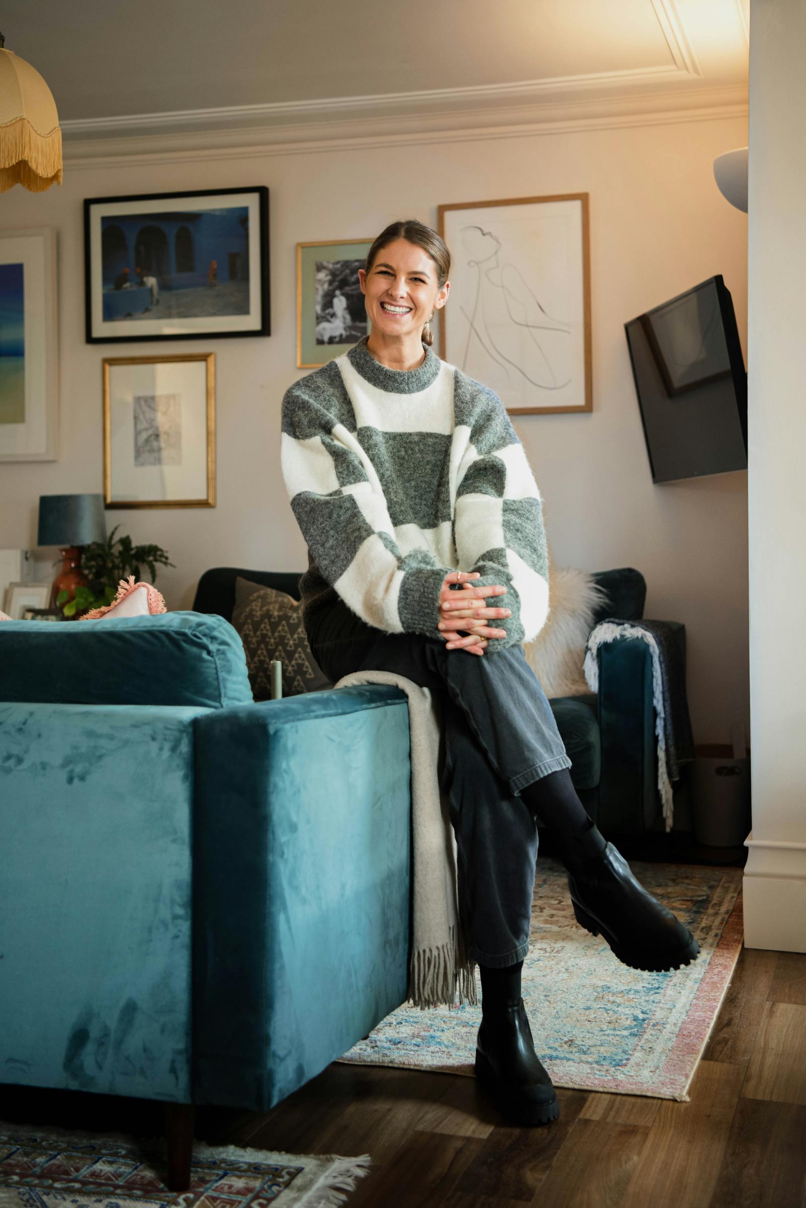 Natasha Bradley smiling and sitting on couch