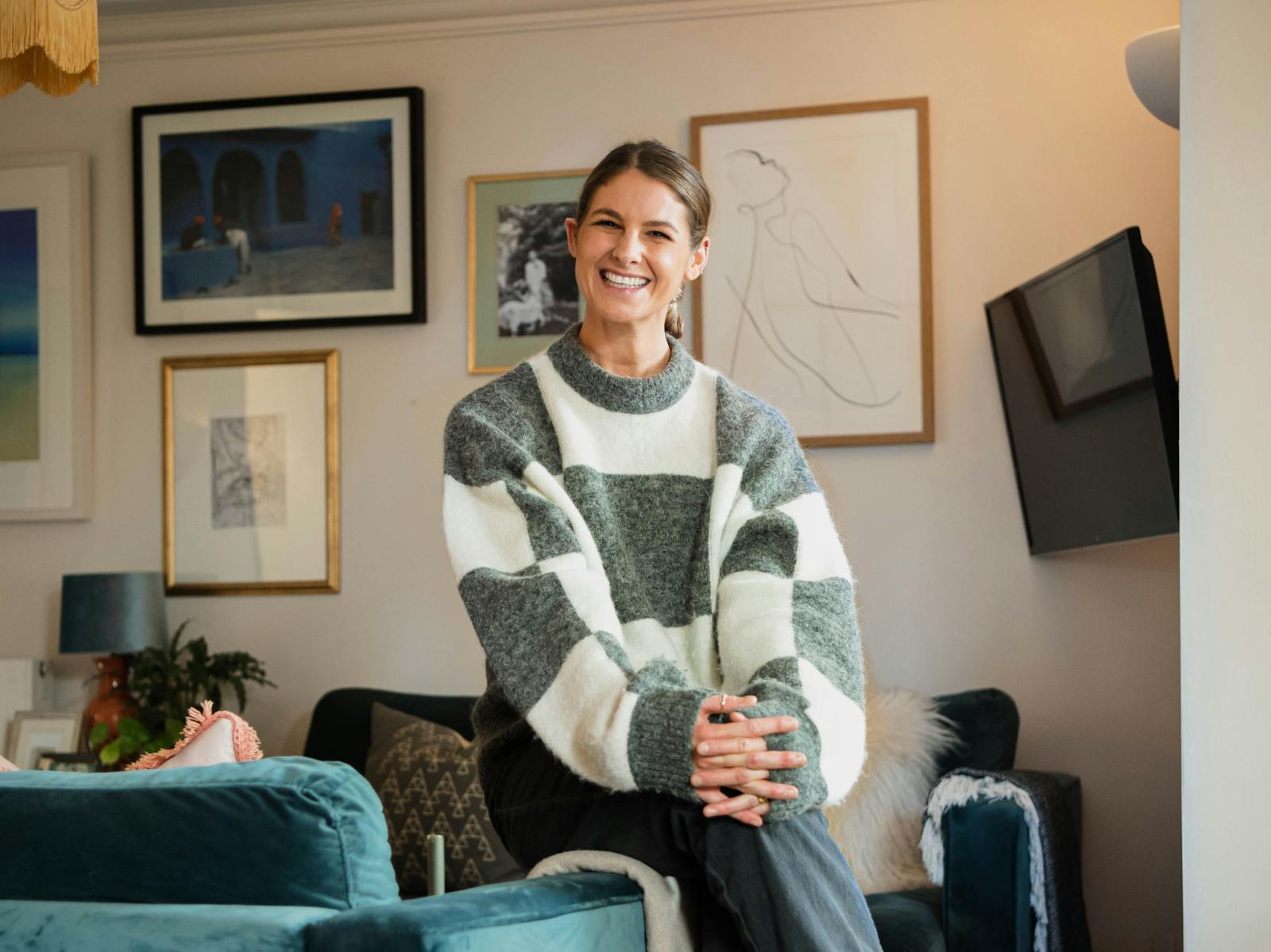 Natasha Bradley smiling and sitting on couch