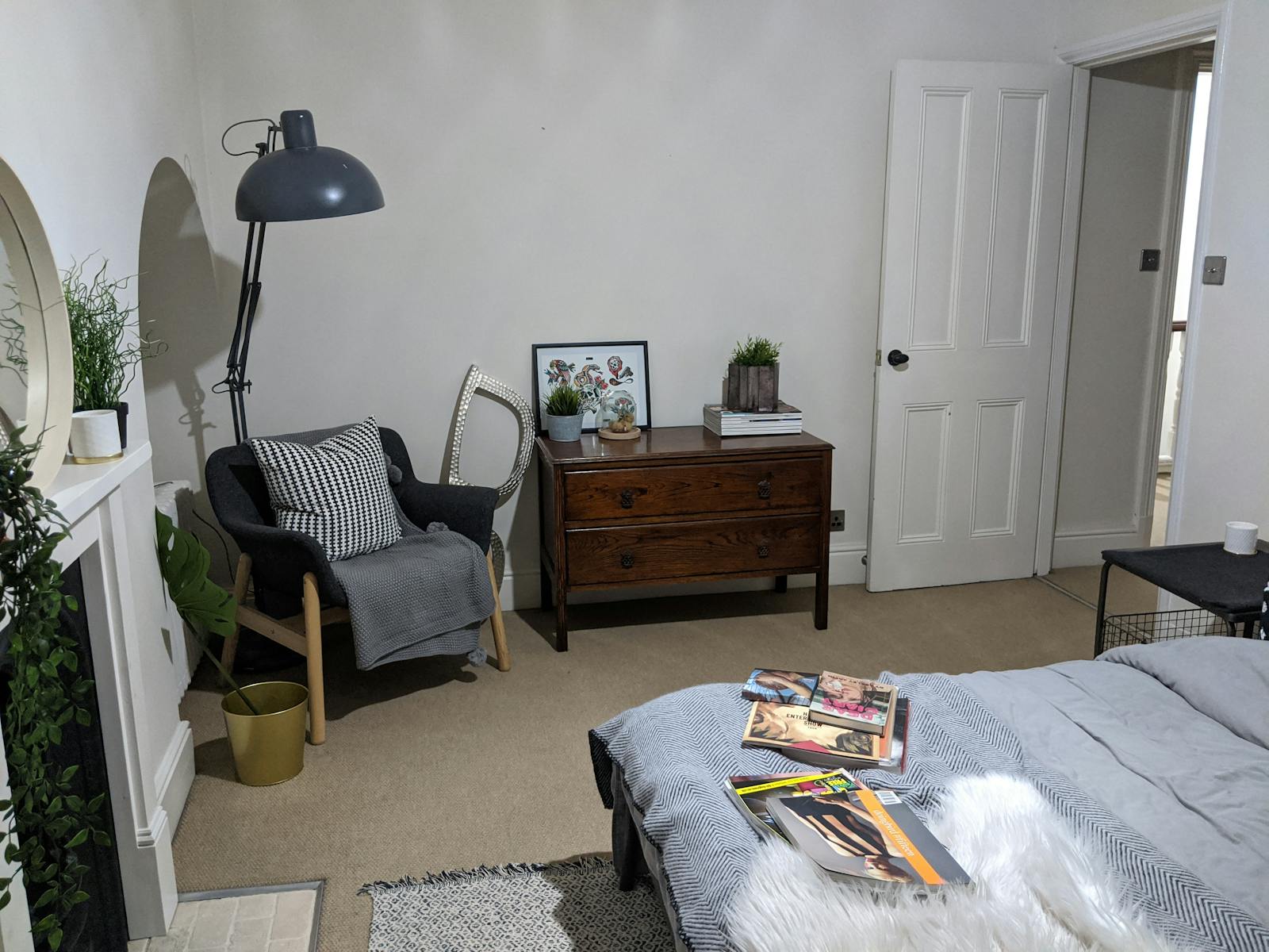 Bedroom in with white walls decorated with cabinet and a grey one-seater