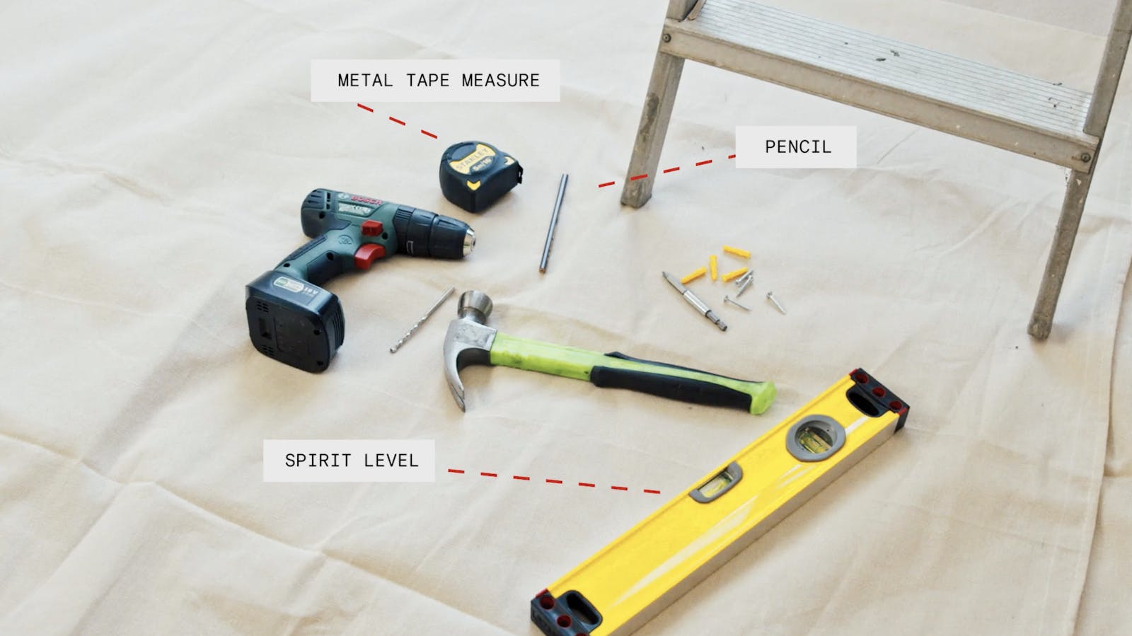 Metal tape measure, pencil and spirit level on floor