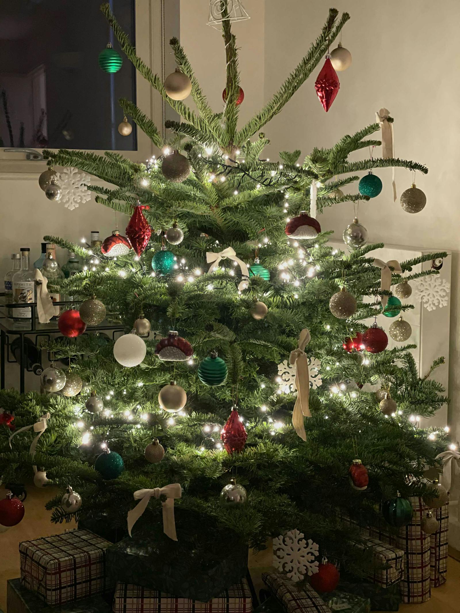 Christmas tree decorated in green, gold, white and red baubles, with white ribbons and nigiri shaped baubles
