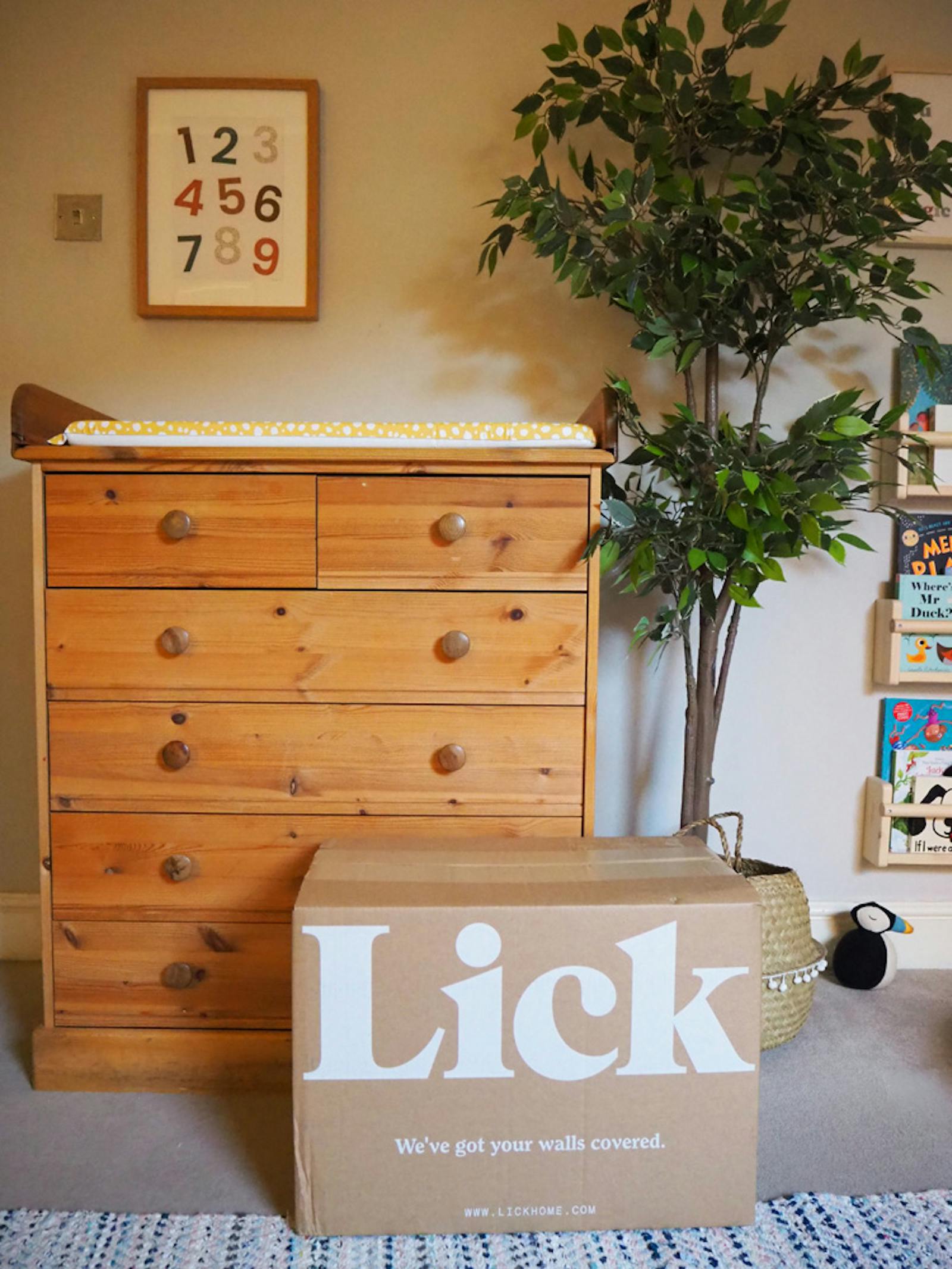 Lick box of paint in front of baby changing table